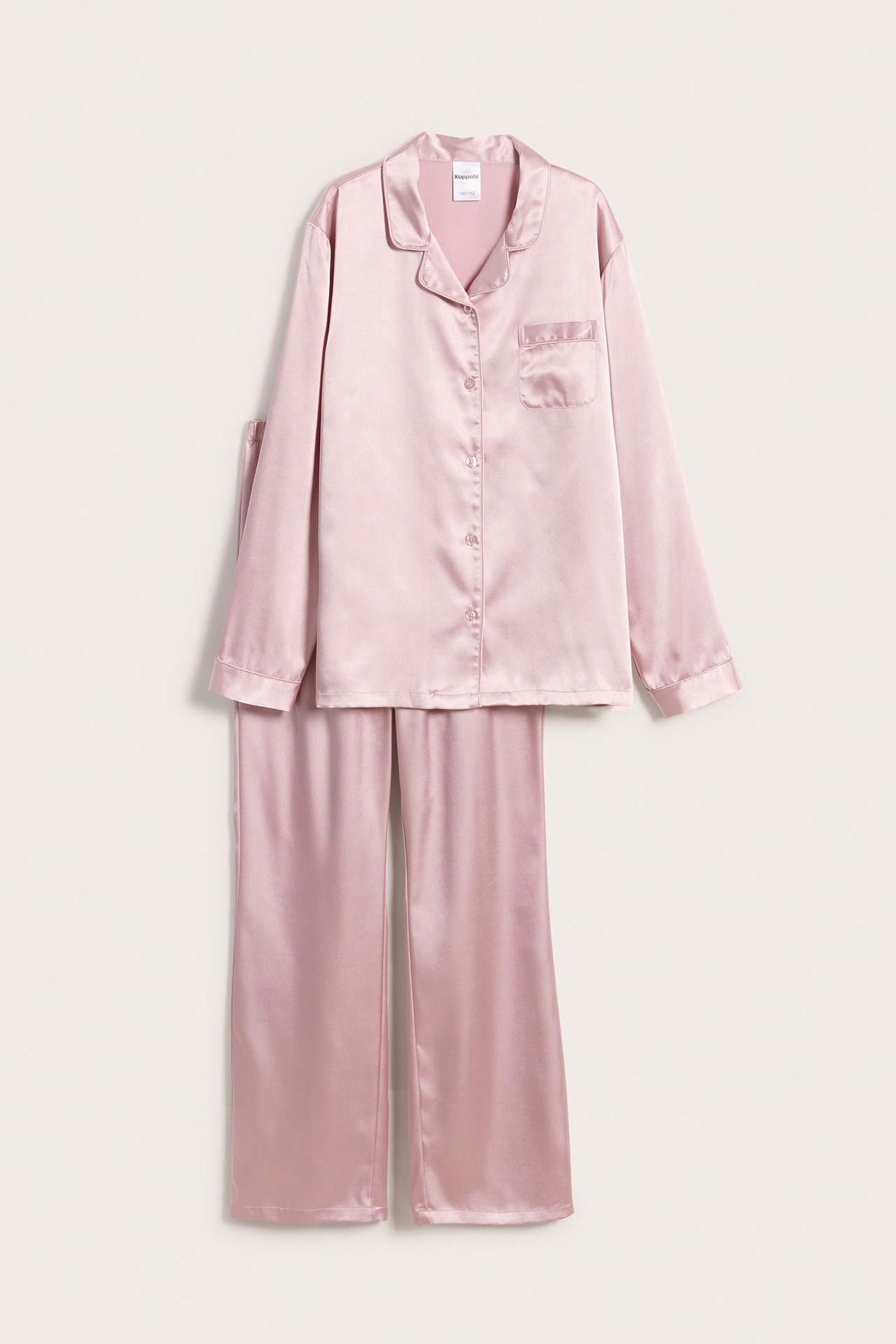 Framifrån: rosa pyjamas i satin med långärmad knäppt överdel med ficka och vida byxor.