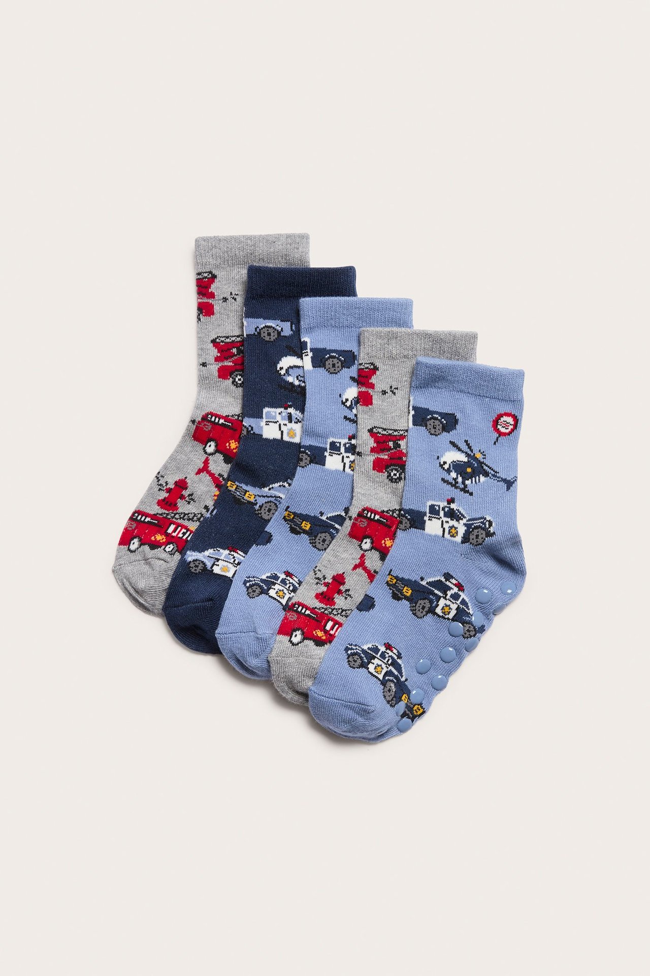 Lähikuva viidestä parista lasten harmaista, tummansinisistä ja vaaleansinisistä sukista ajoneuvoprinteillä.