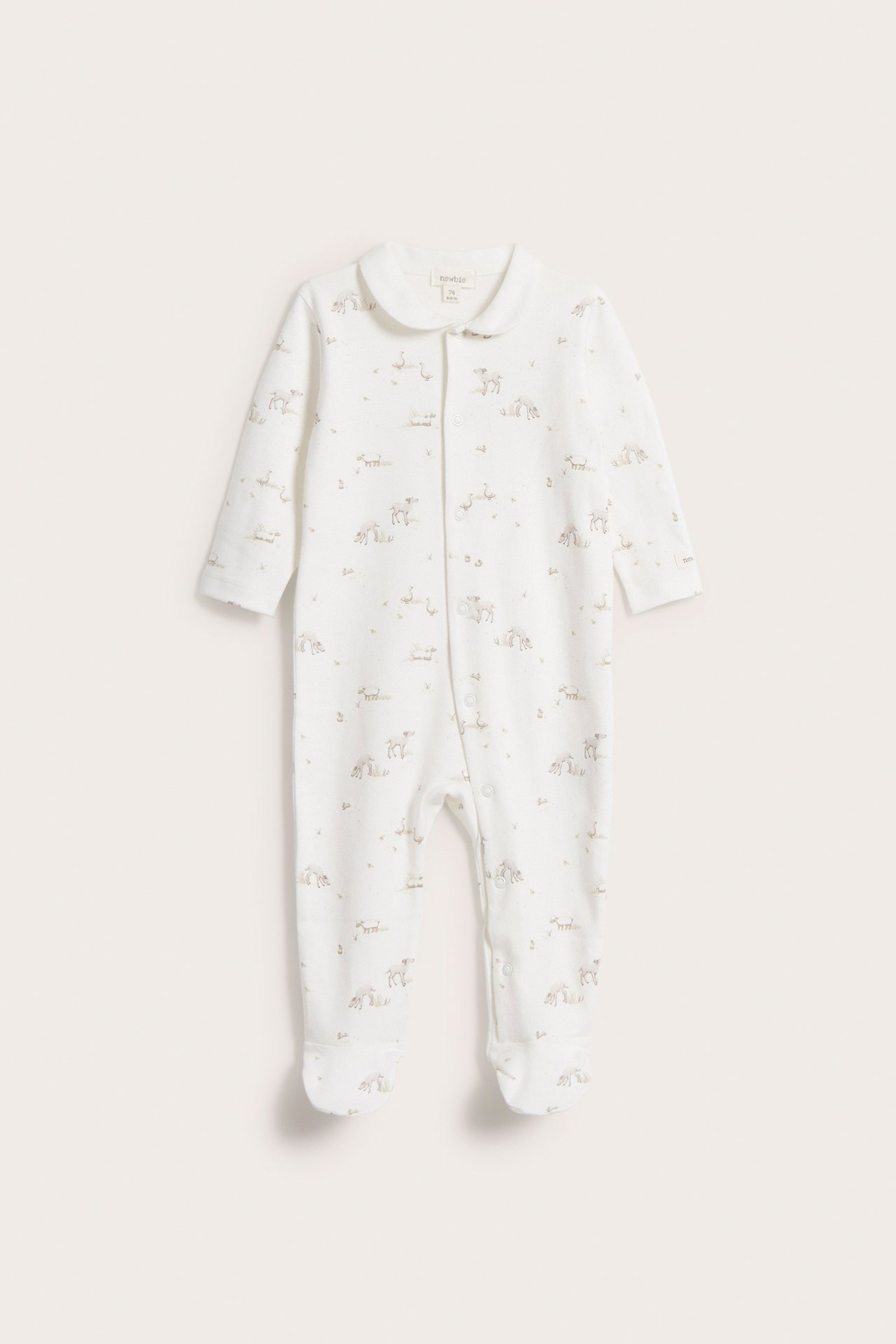 Framifrån: Offwhite baby-pyjamas i bomull med djurmönster, krage och tryckknappar framtill.