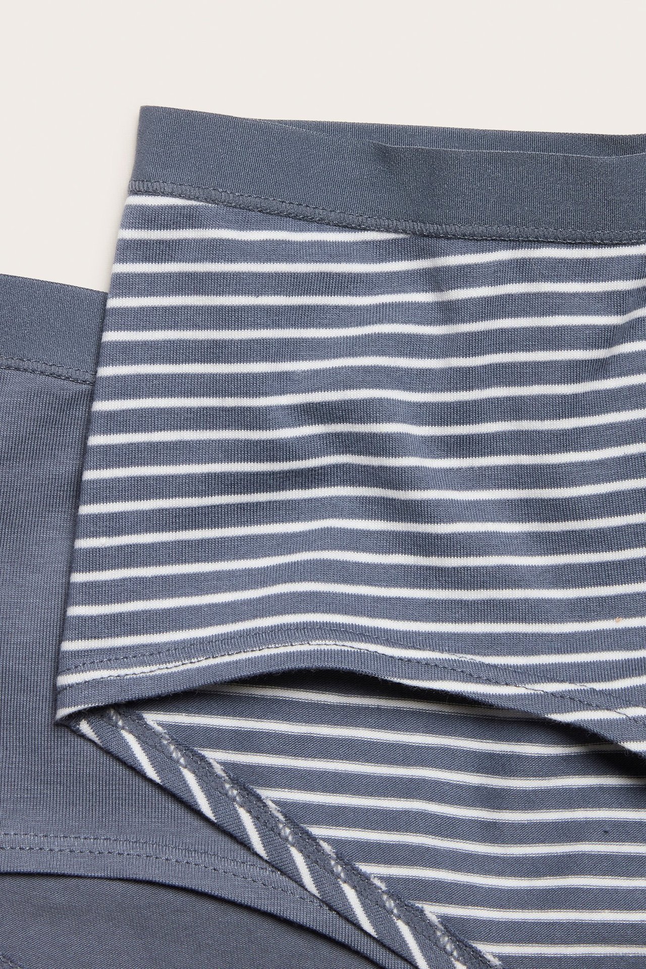 Zbliżenie damskich szaro-białych bawełnianych fig typu hipster w paski, z jednolitą szarą parą.