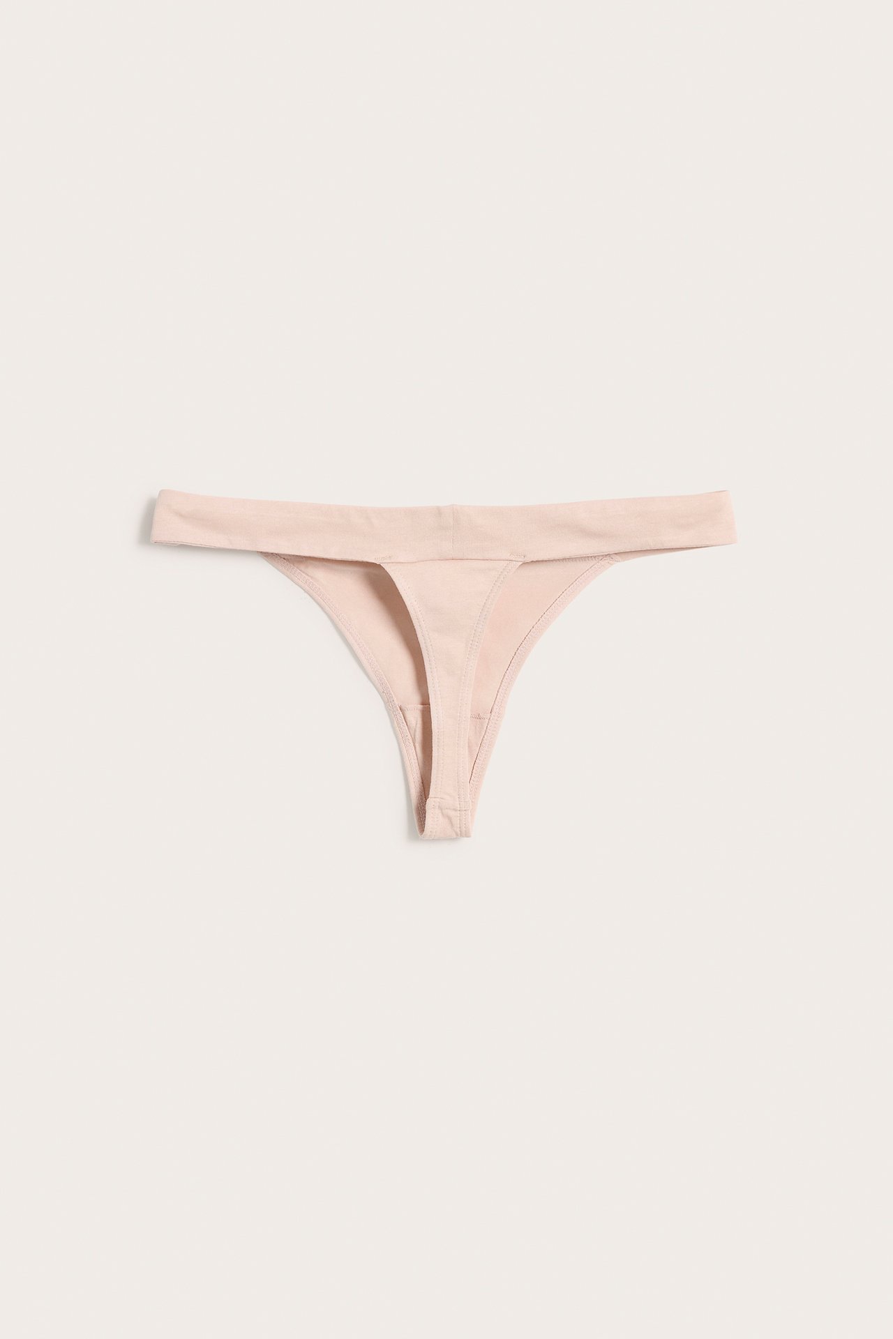 Forfra, en lys rosa ensfarget bomullsblanding stringtruse, flatlagt.