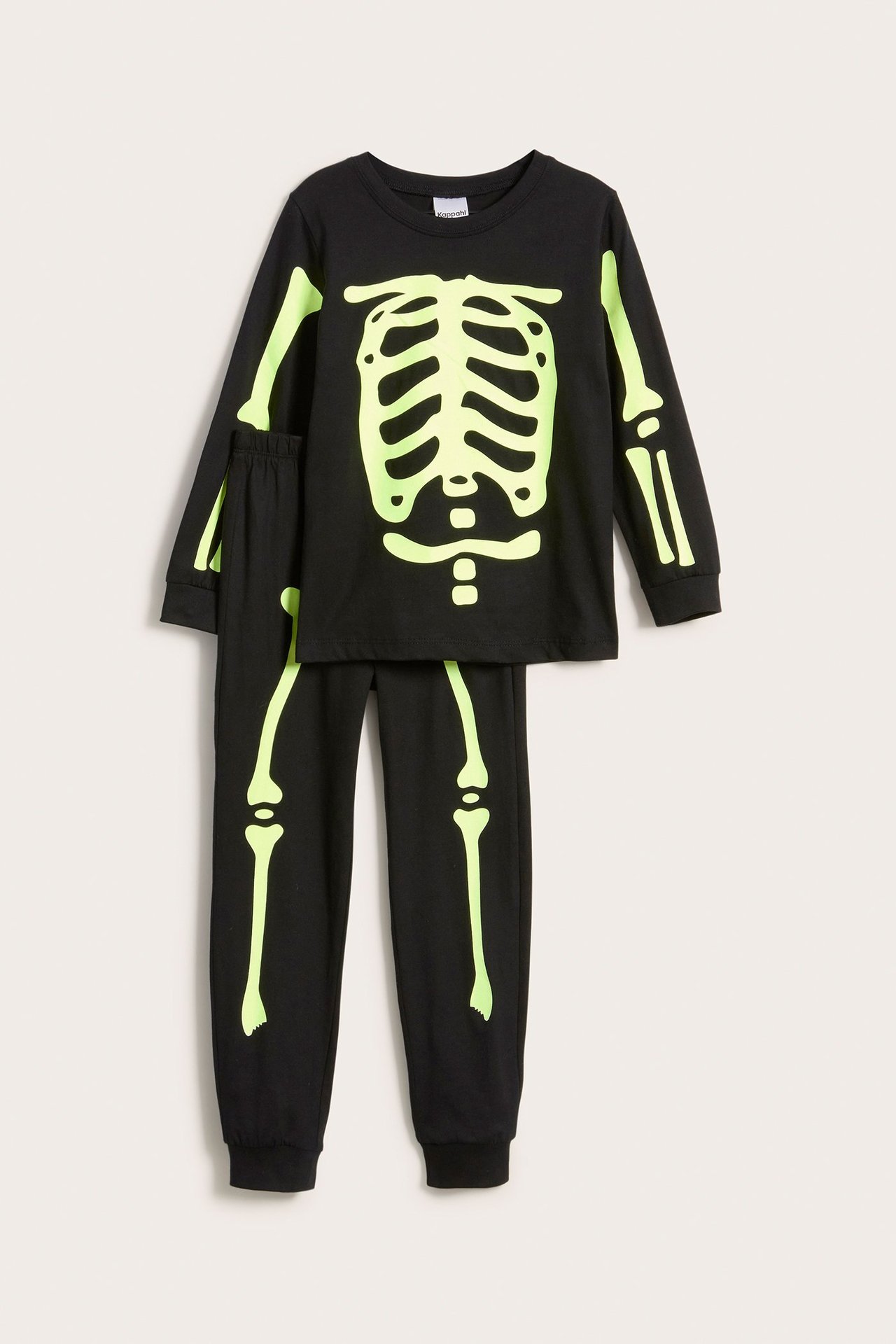 Edestä näkymä lasten mustasta puuvillapyjamasetistä, jossa on pimeässä hohtava luurankoprintti.