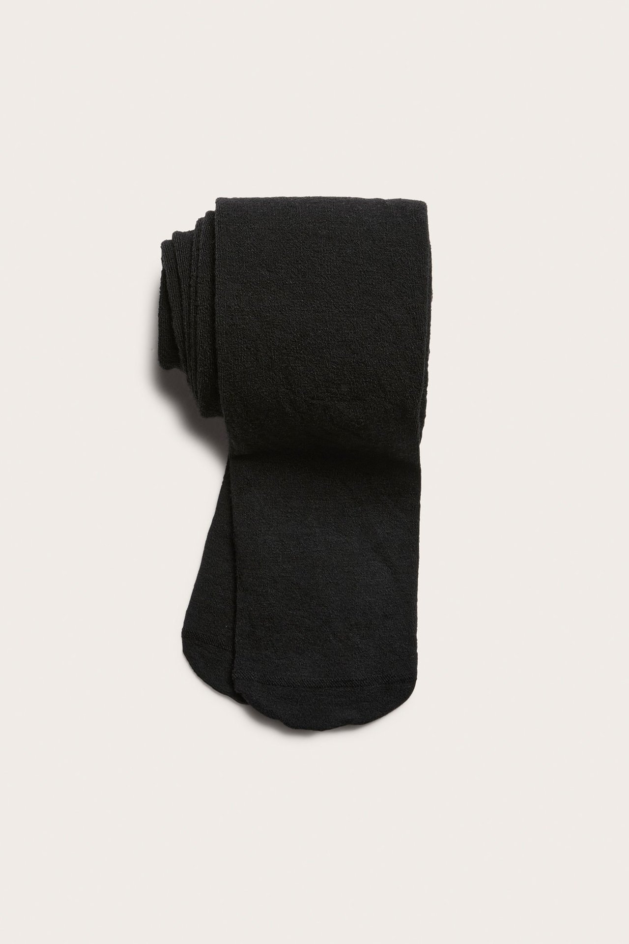 Widok z góry na złożone czarne gładkie rajstopy z mieszanki wełny.