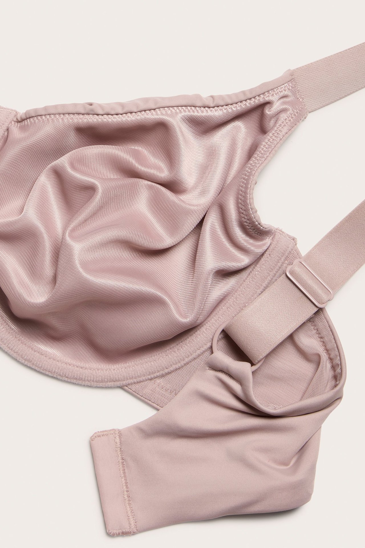 Zbliżenie różowego biustonosza minimizer z fiszbinami i regulowanymi ramiączkami.