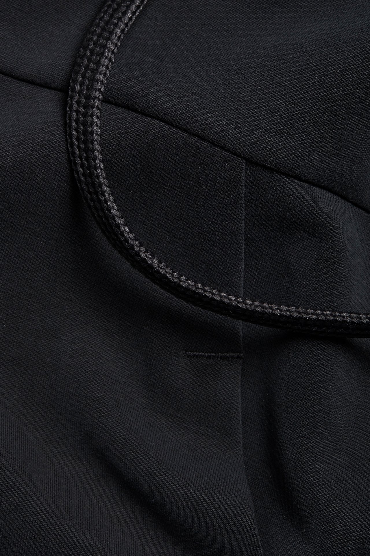 Närbild av en svart hoodie i mjuk Tencel/modal-mix, med svart dragsko.