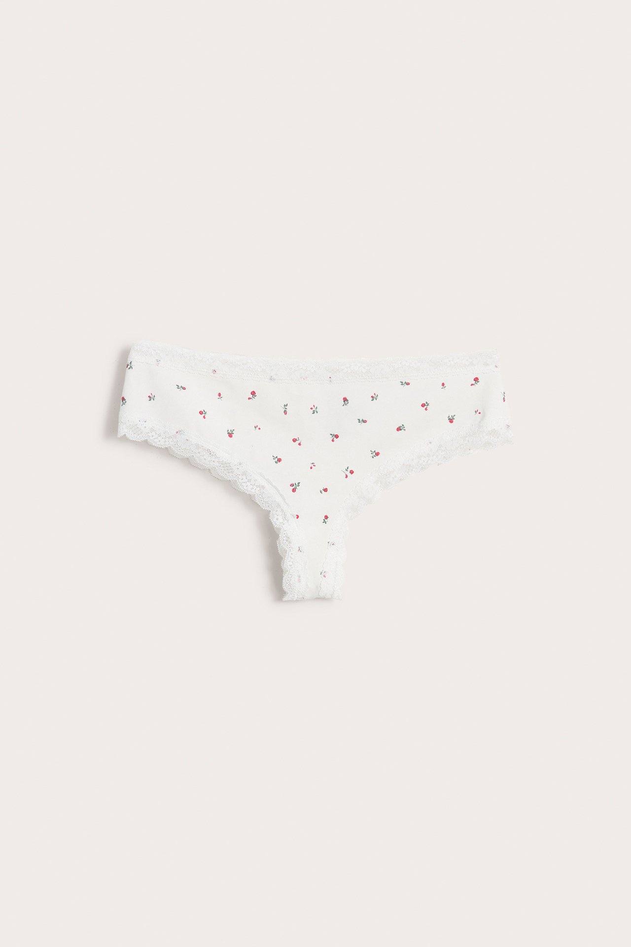 Framifrån, offwhite cheeky trosa för dam med litet rött blommönster och vit spetskant.