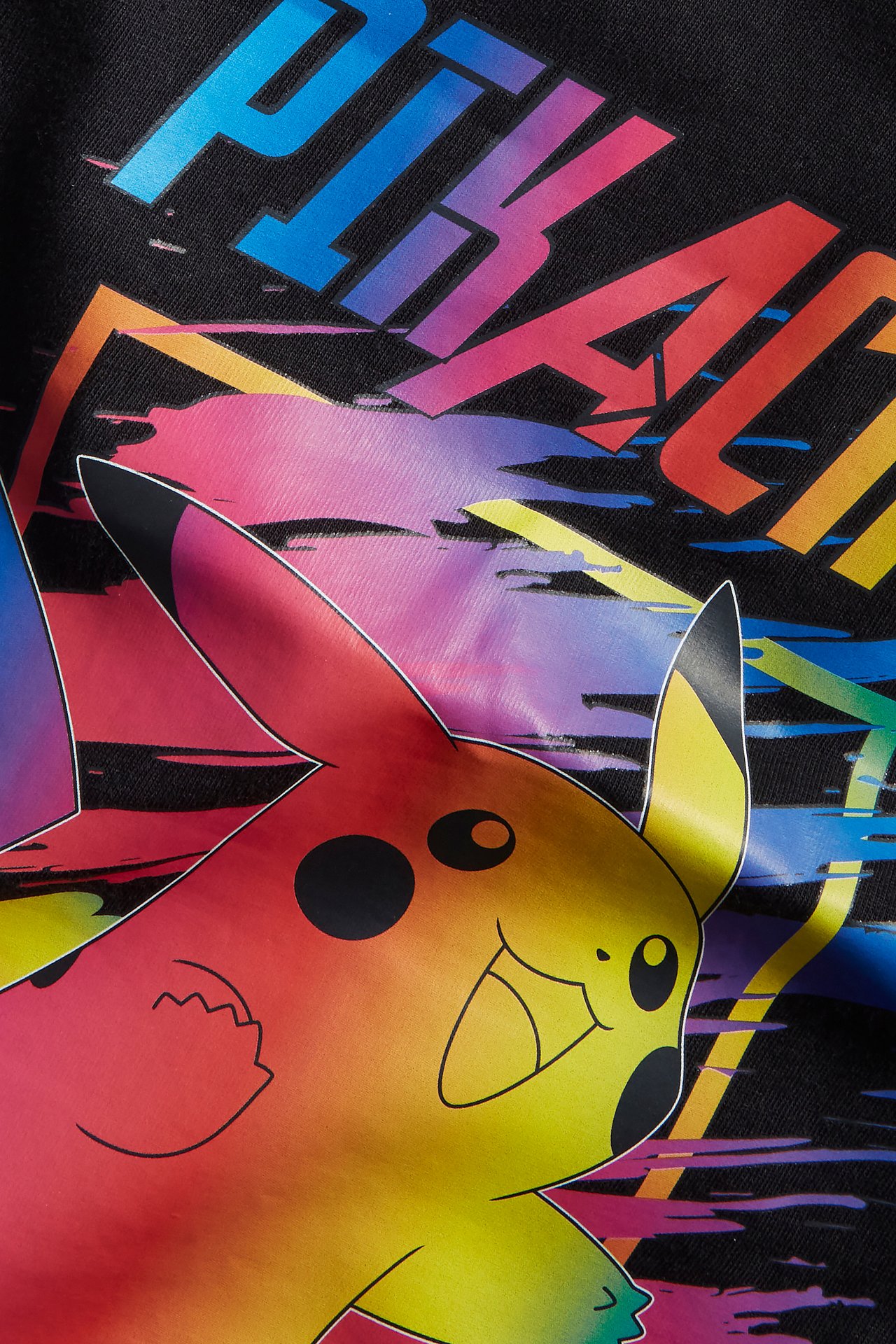 Lähikuva lasten mustasta puuvilla-T-paidasta, jossa on värikäs Pikachu- ja tekstipainatus edessä.