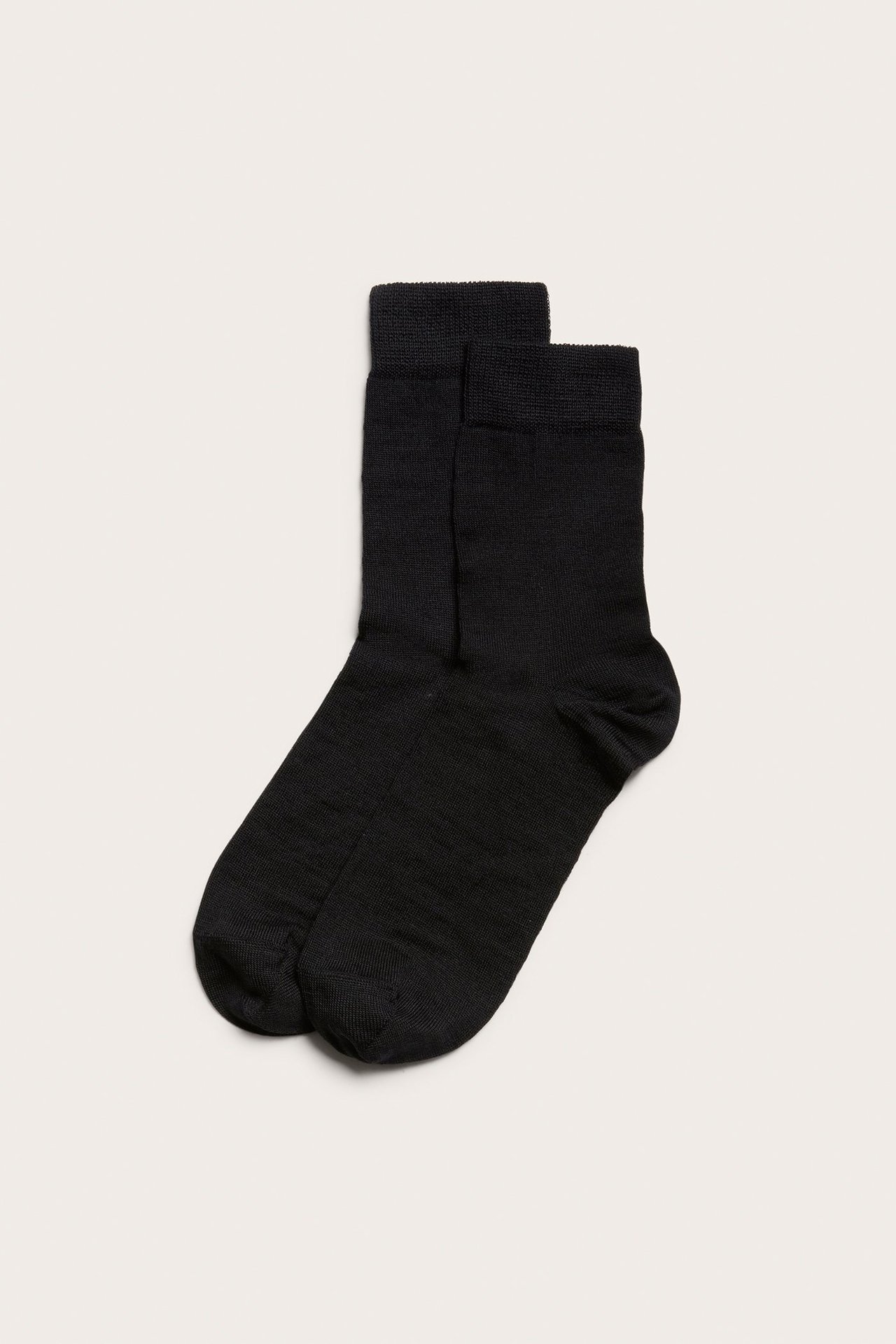 Ovenfra sett par svarte ullblandingssokker med kort mansjett.