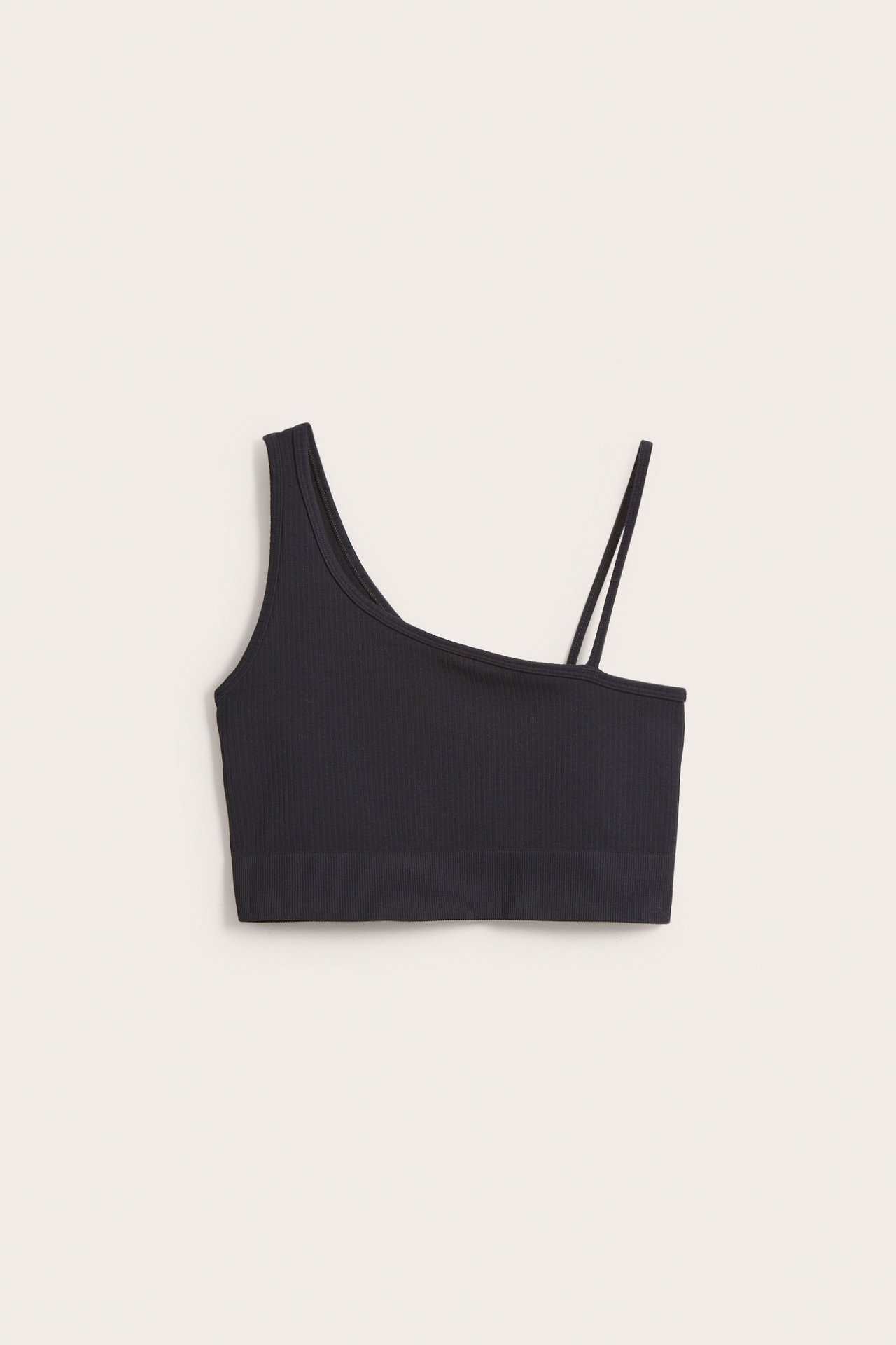 Widok z przodu czarnego, prążkowanego asymetrycznego topu sportowego z jednym szerokim i dwoma cienkimi ramiączkami.