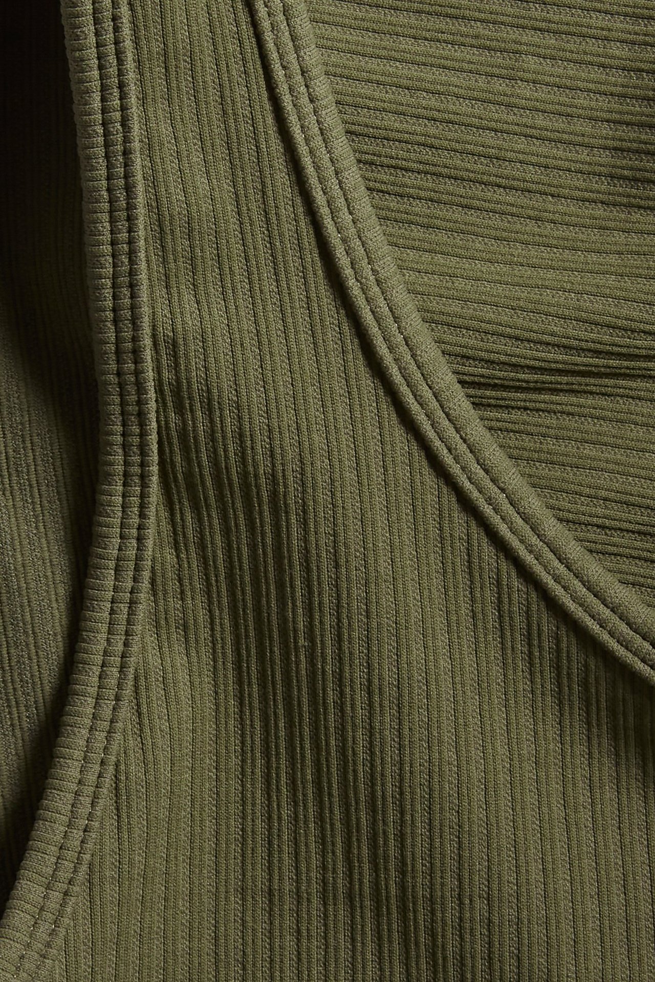 Zbliżenie zielonego, prążkowanego, asymetrycznego topu sportowego o bezszwowej jakości.