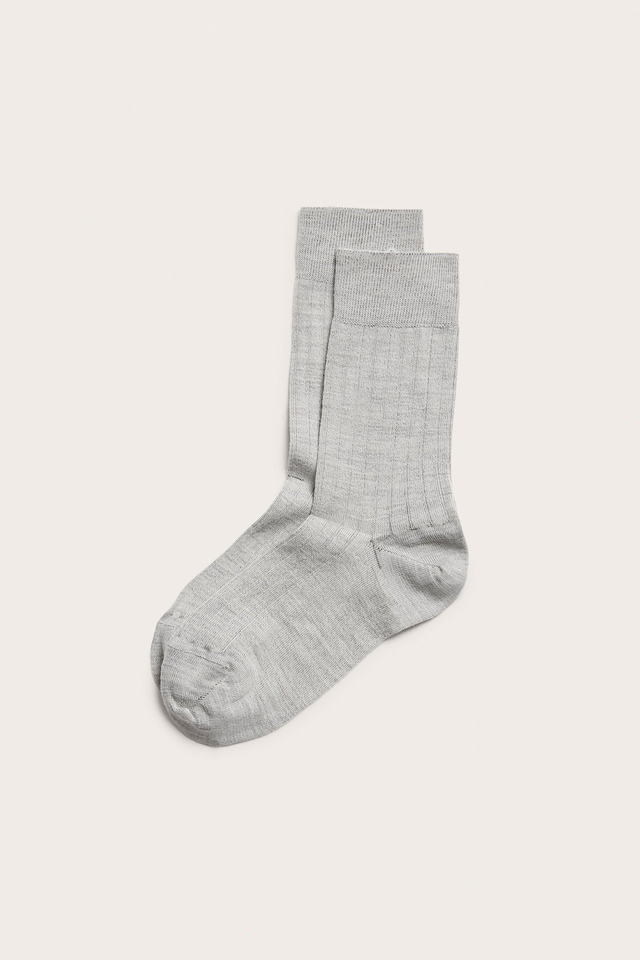 Widok z góry na parę jasnobeżowych, prążkowanych skarpet z mieszanki wełny.