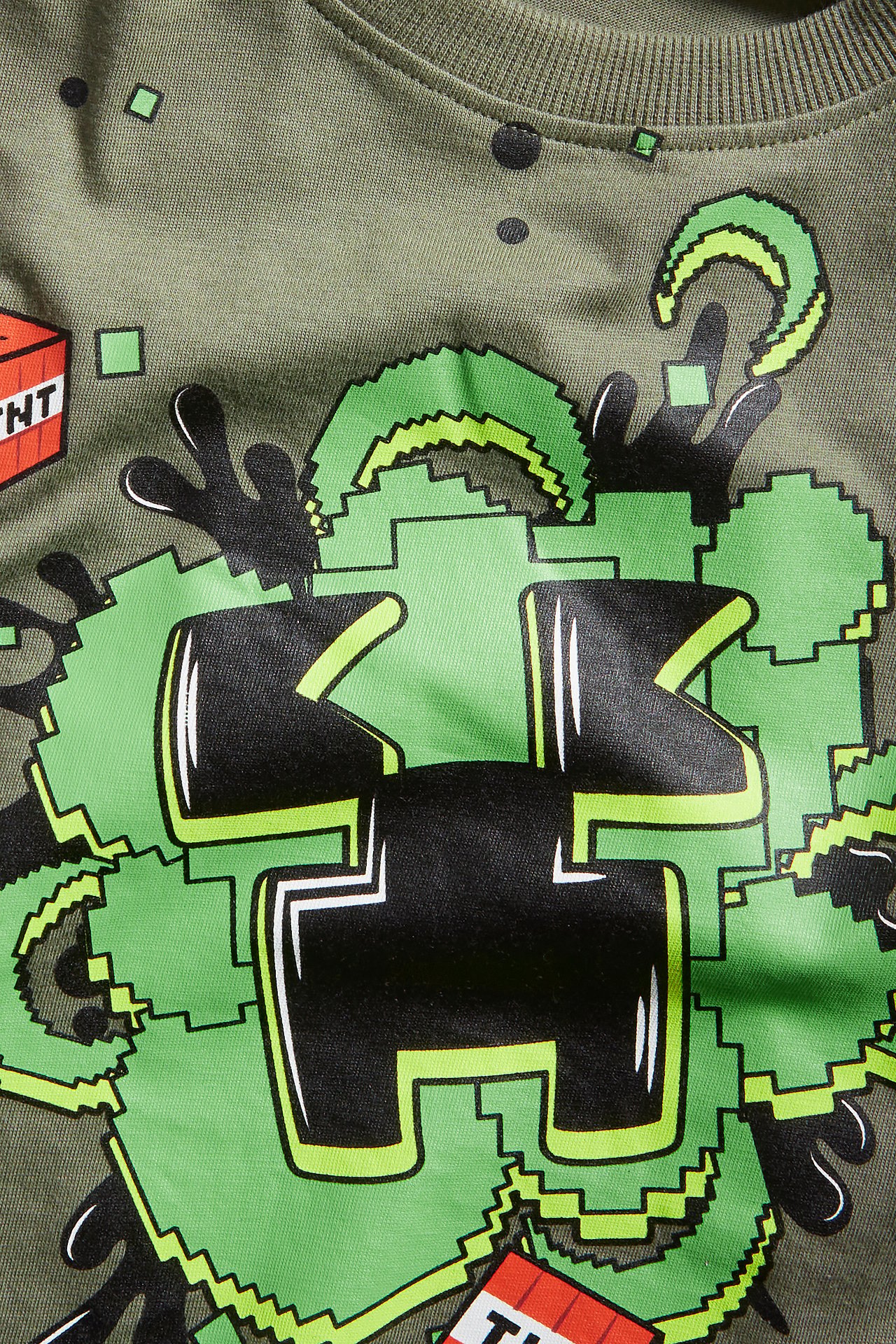 Närbild av en mörkgrön långärmad t-shirt i bomull med stort grönt och svart Minecraft Creeper-tryck.