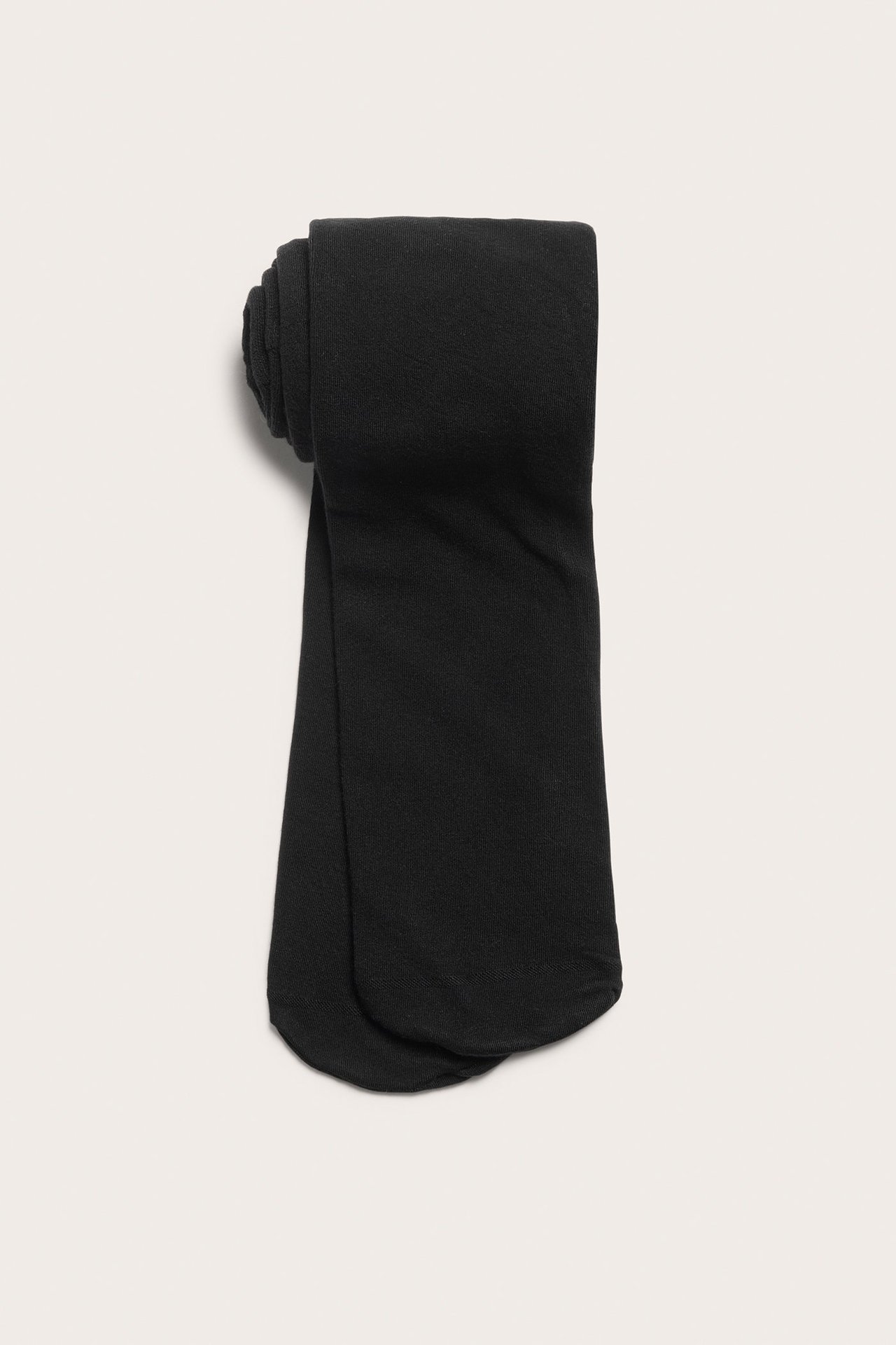 Ylhäältä näkymä mustista, yksivärisistä, pehmeistä Lyocell-sekoite sukkahousuista, siististi taiteltuna.