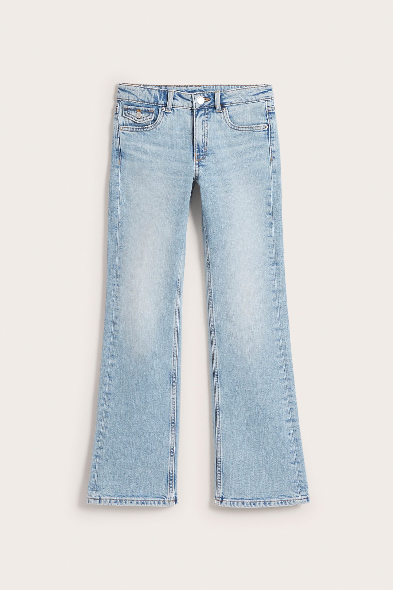 Edestä: Vaaleansiniset matalavyötäröiset bootcut-farkut etutaskuilla, puuvillasekoitetta.