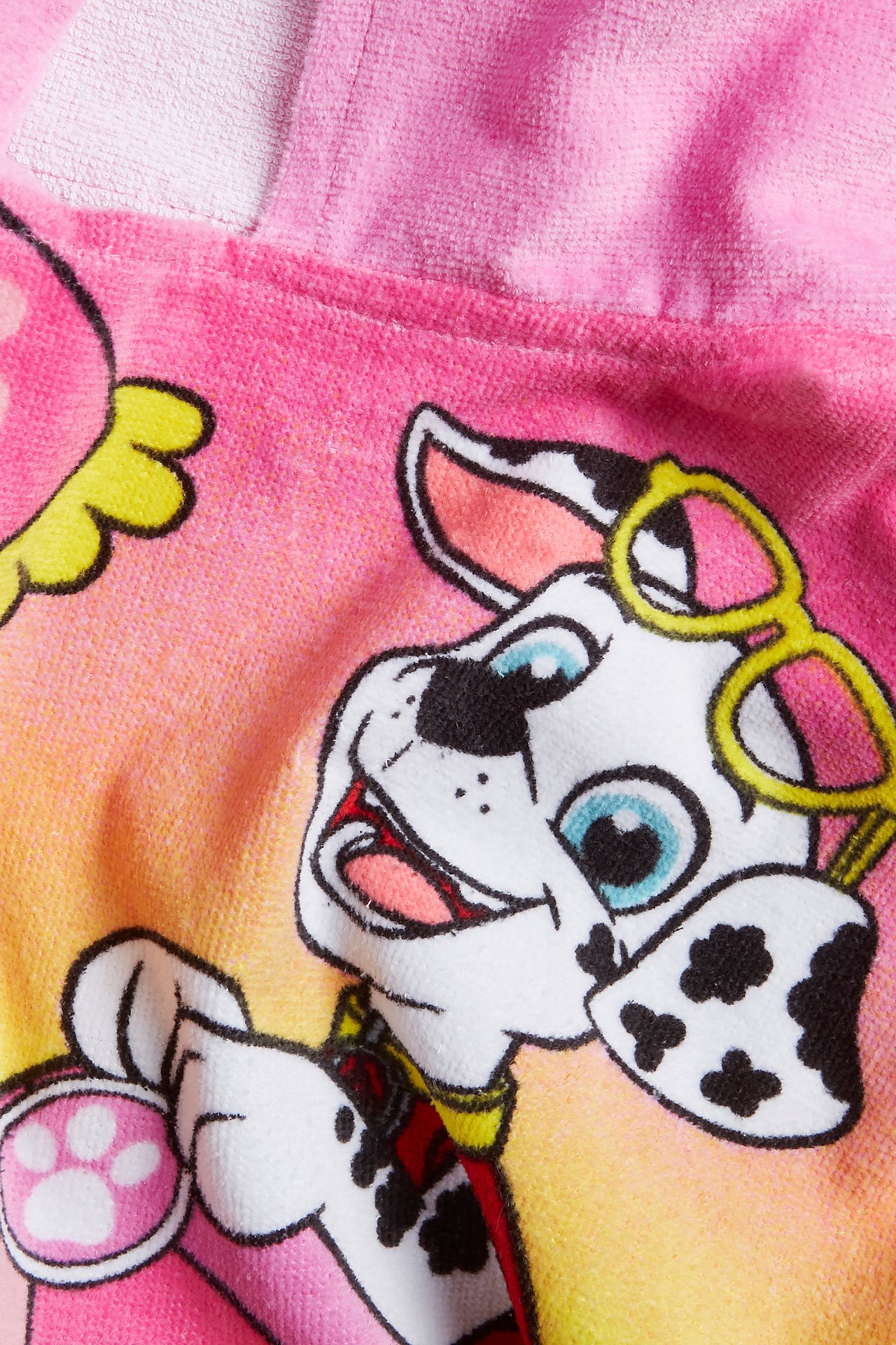 Närbild av en rosa frottéponcho för barn med färgglatt Paw Patrol Marshall-tryck.