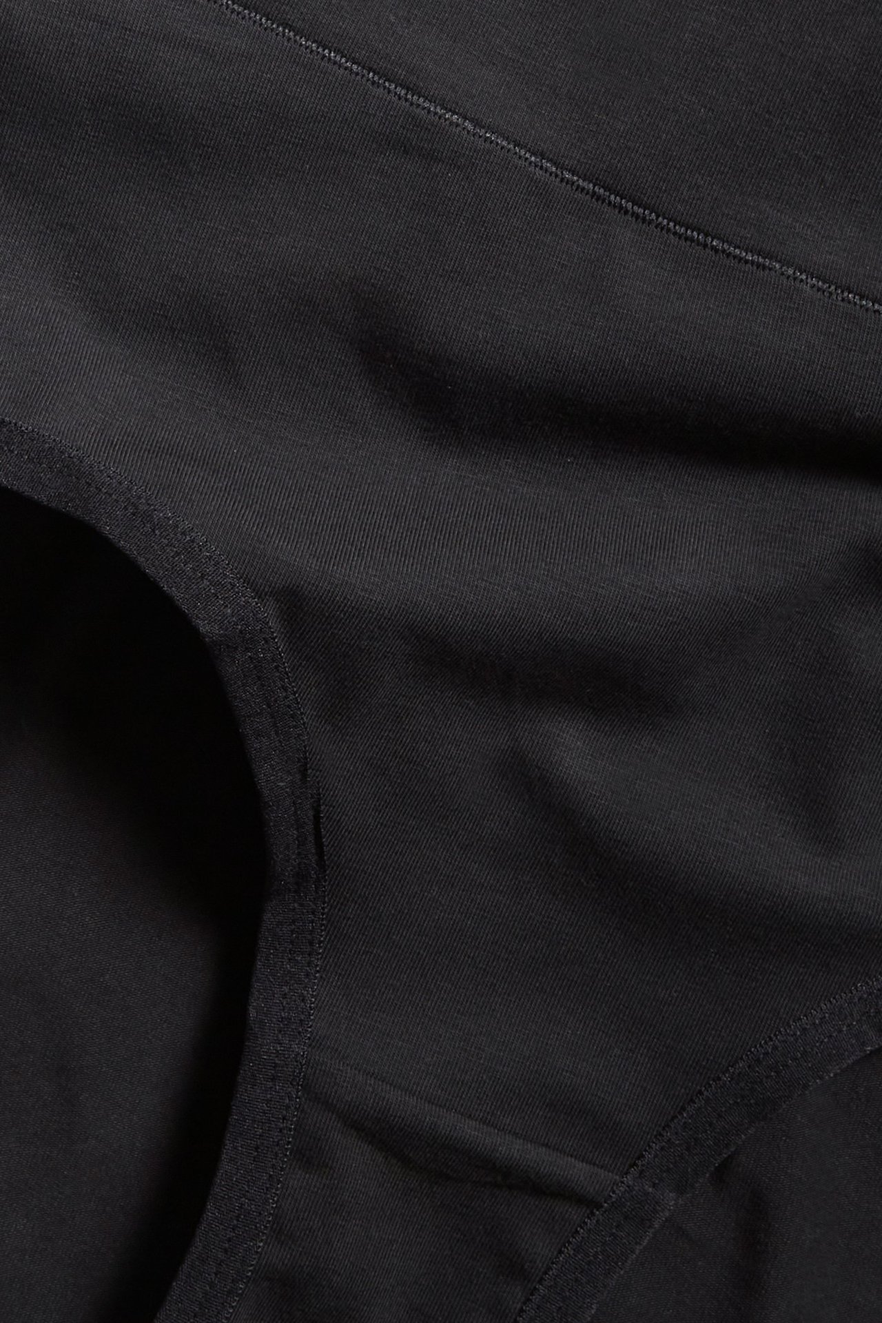 Zbliżenie na czarne bawełniane figi typu hipster z szerokim elastycznym pasem.