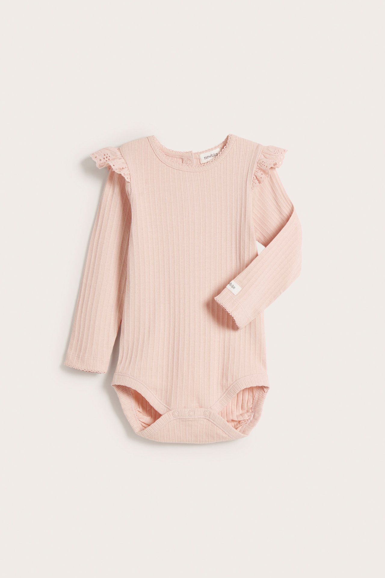Frontvisning av en lyserosa ribbet babybody med lange ermer, skulderkapper og trykknapper.
