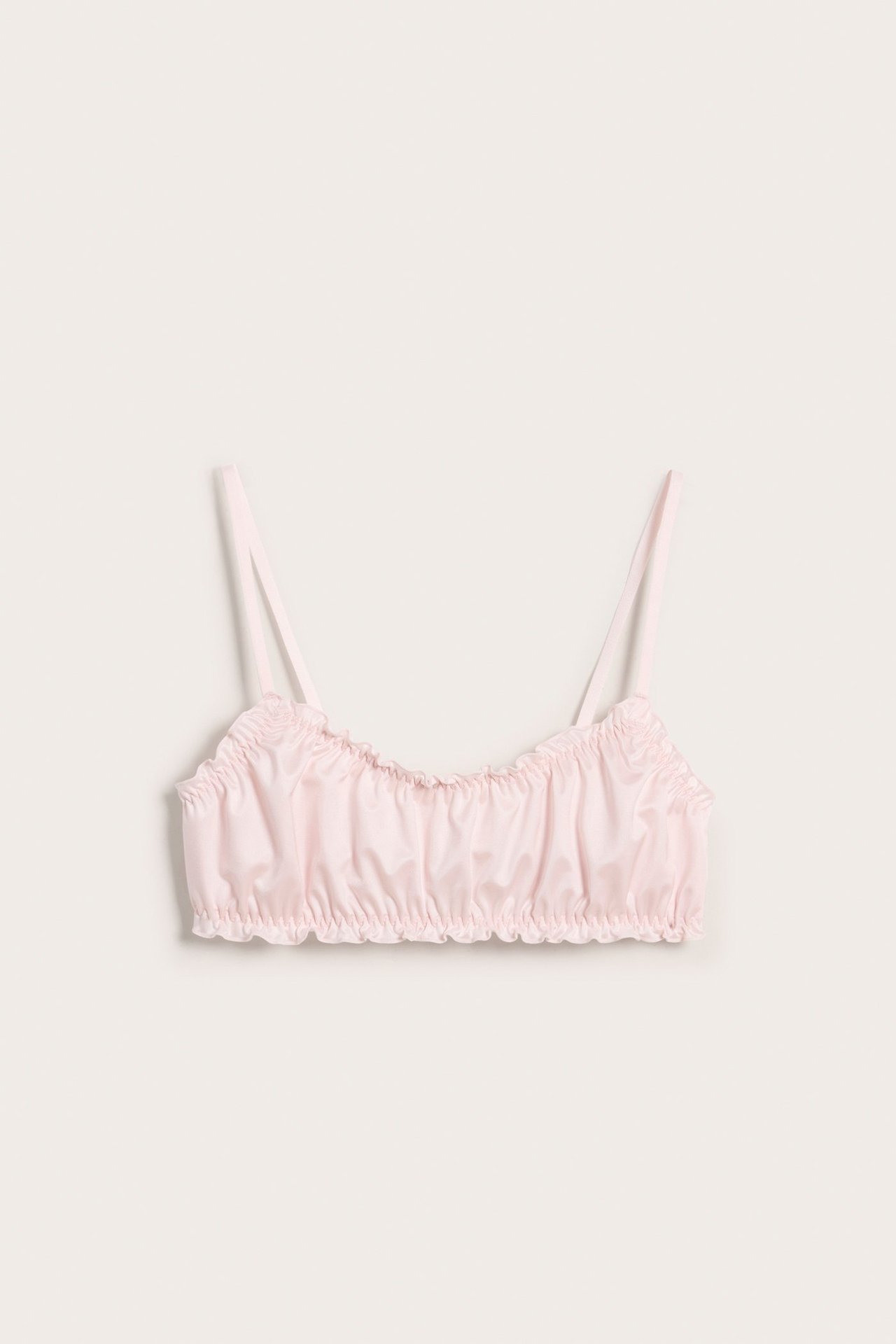 Framifrån, rosa bralette i satin med tunna axelband och rynkade detaljer.