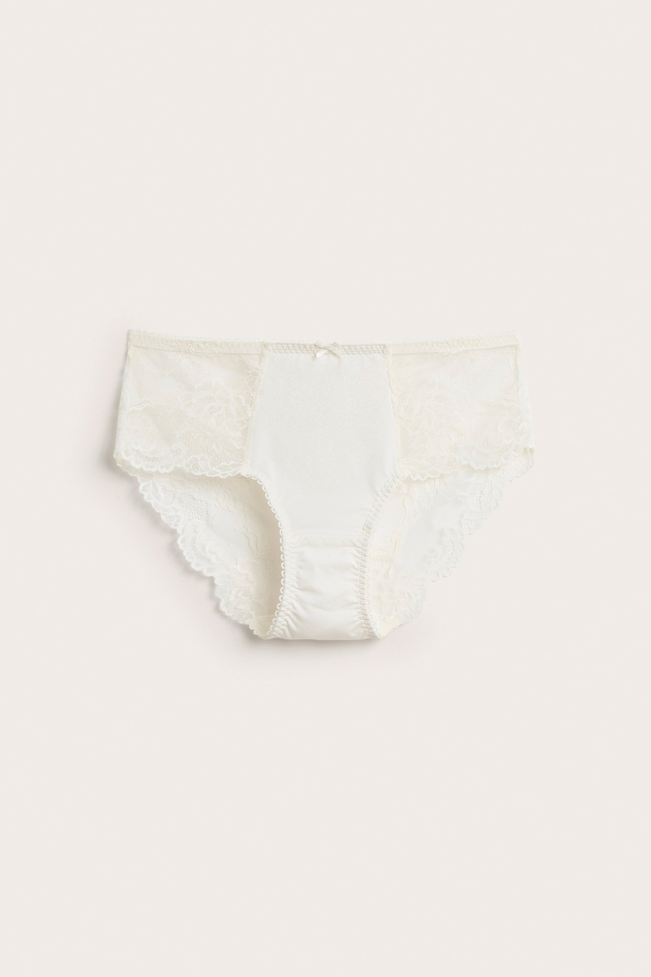 Frontvisning av offwhite blonde-briefs med mikropanel foran og liten sløyfe.