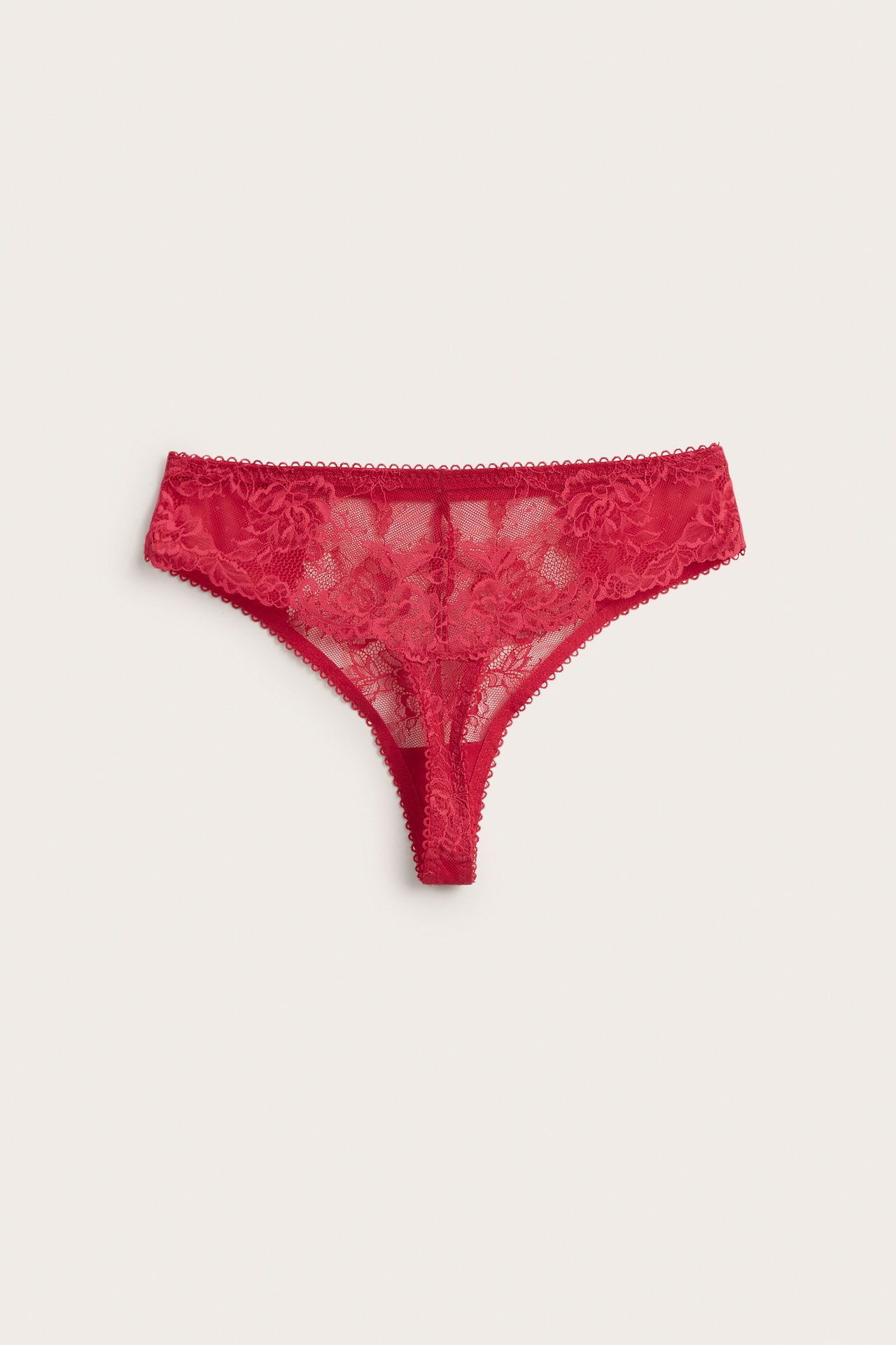 Forfra, rød blondestringtrusa med delikat blomstermønster.