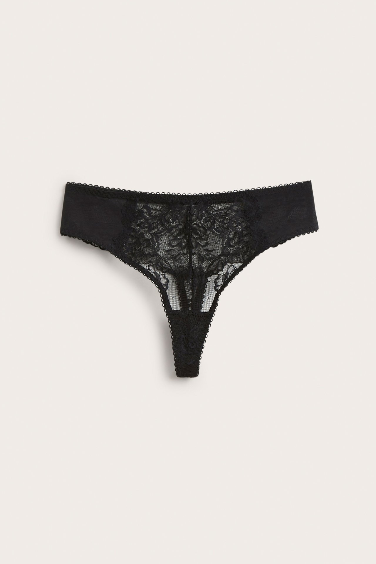 Framifrån, svart spetsstringtrosa med blommigt mönster.
