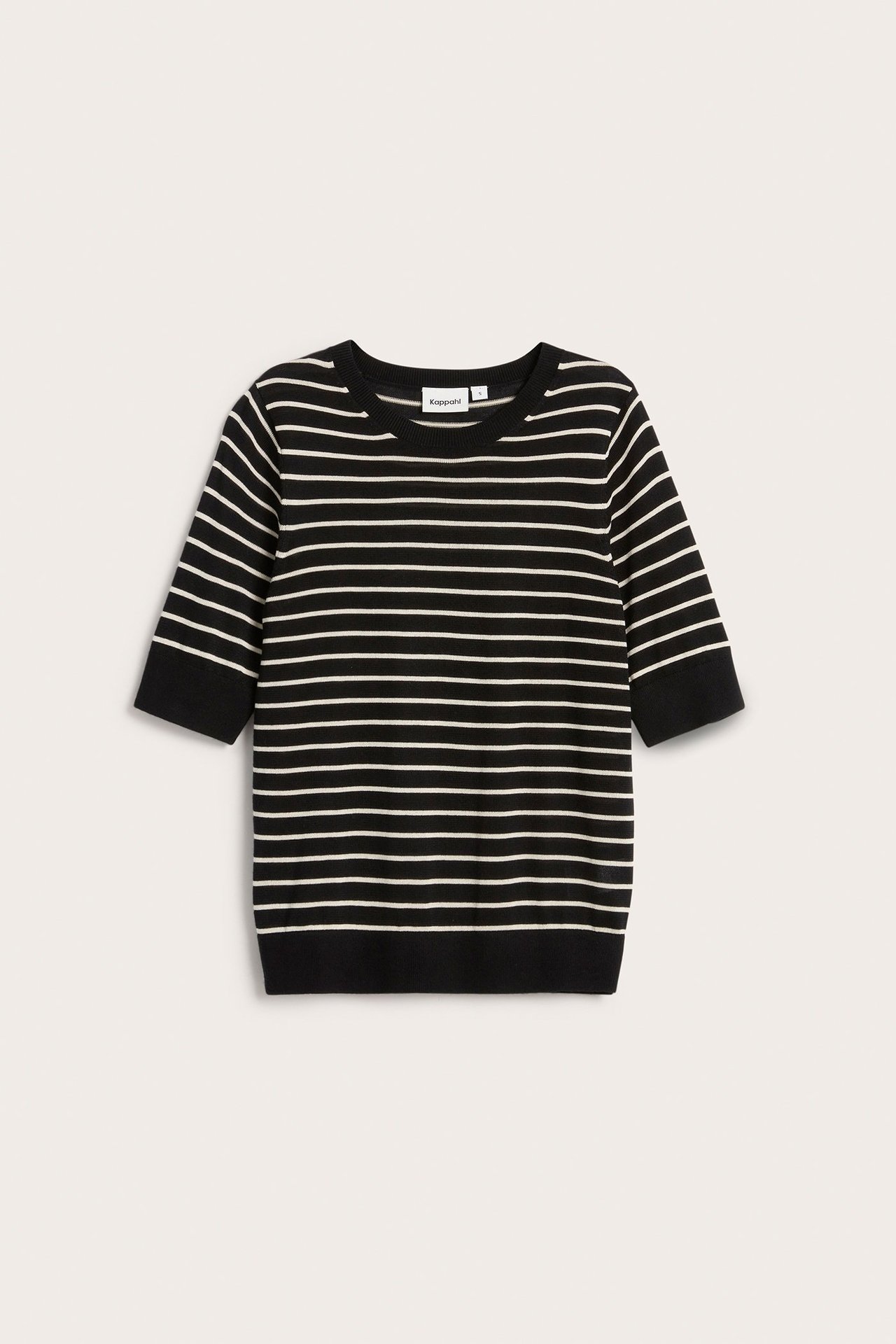 Edestäpäin: musta hienoneulepusero lyhyillä hihoilla ja valkoisilla vaakaraidoilla.