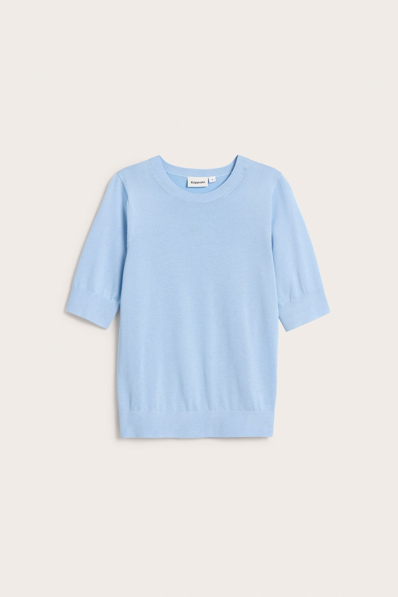 Edestä, vaaleansininen hienoneulottu lyhythihainen pusero.