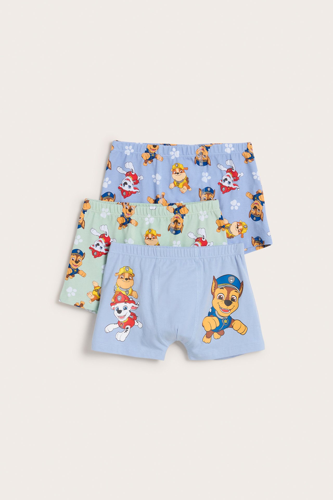 Frontvy av tre barnboxers i bomullsblandning med Paw Patrol: ljusblå med stort tryck, ljusgrön och ljusblå.