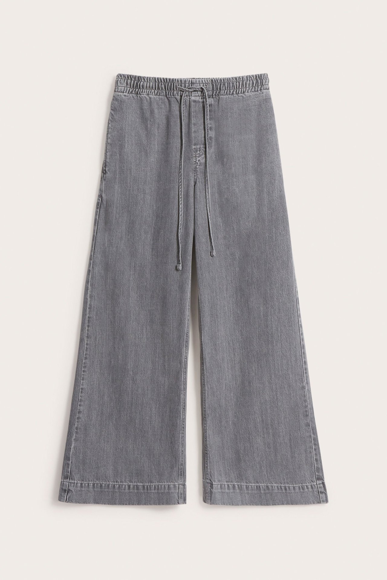 Frontvy av gråa vida pull-on jeans med hög elastisk midja och dragsko.