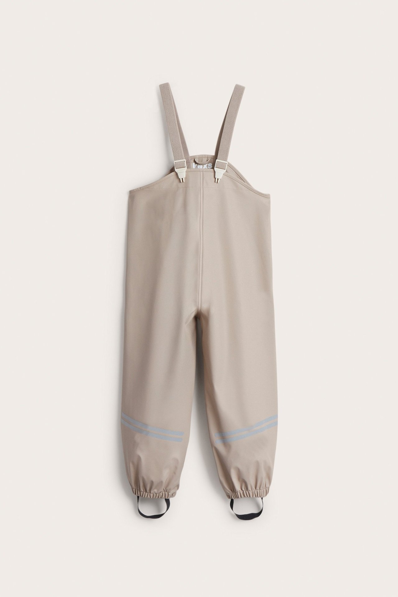Frontvy av beiga regnbyxor för barn med hängslen, resårmuddar och reflexränder.