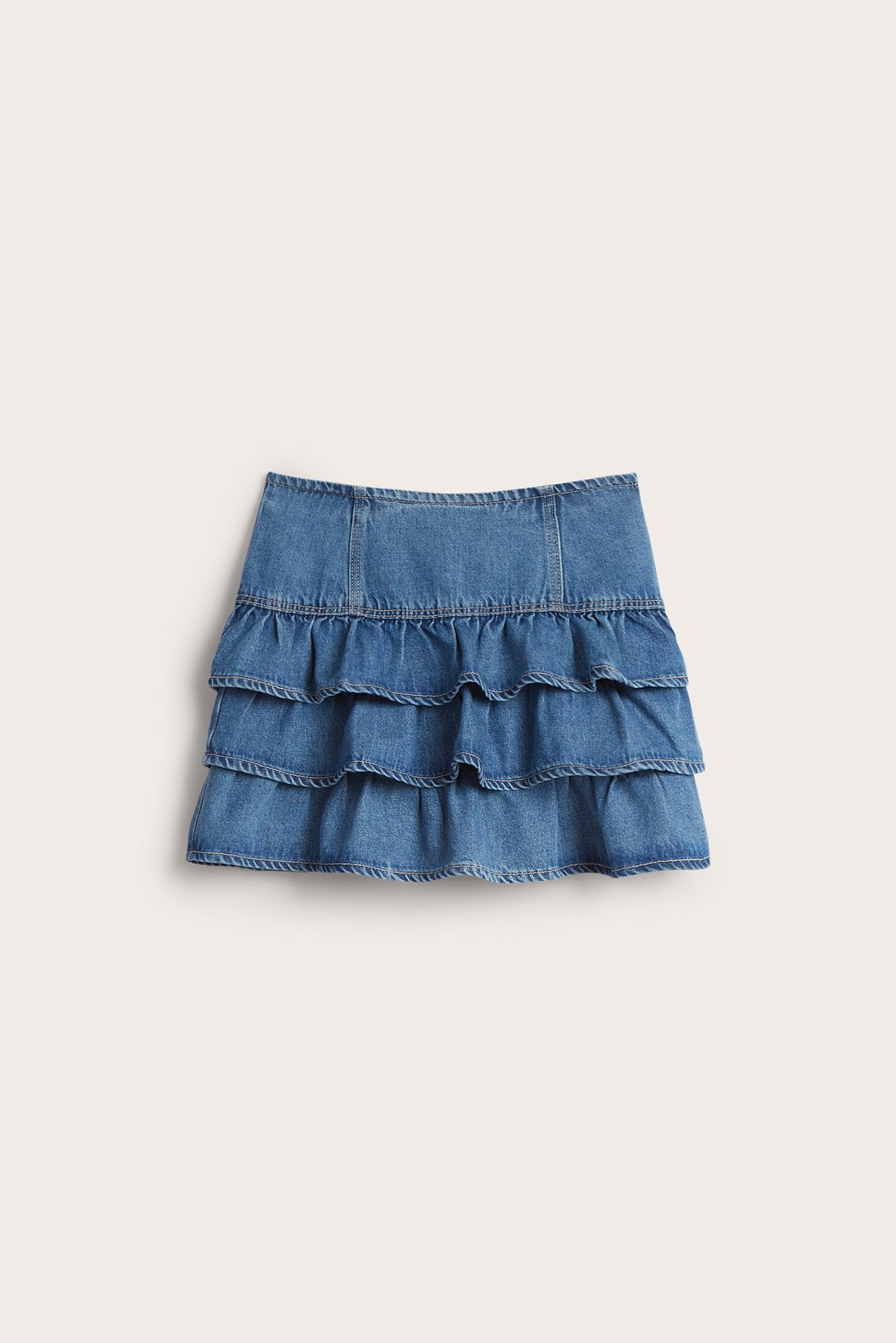 Framifrån, ljusblå denimkjol med tre volanglager.