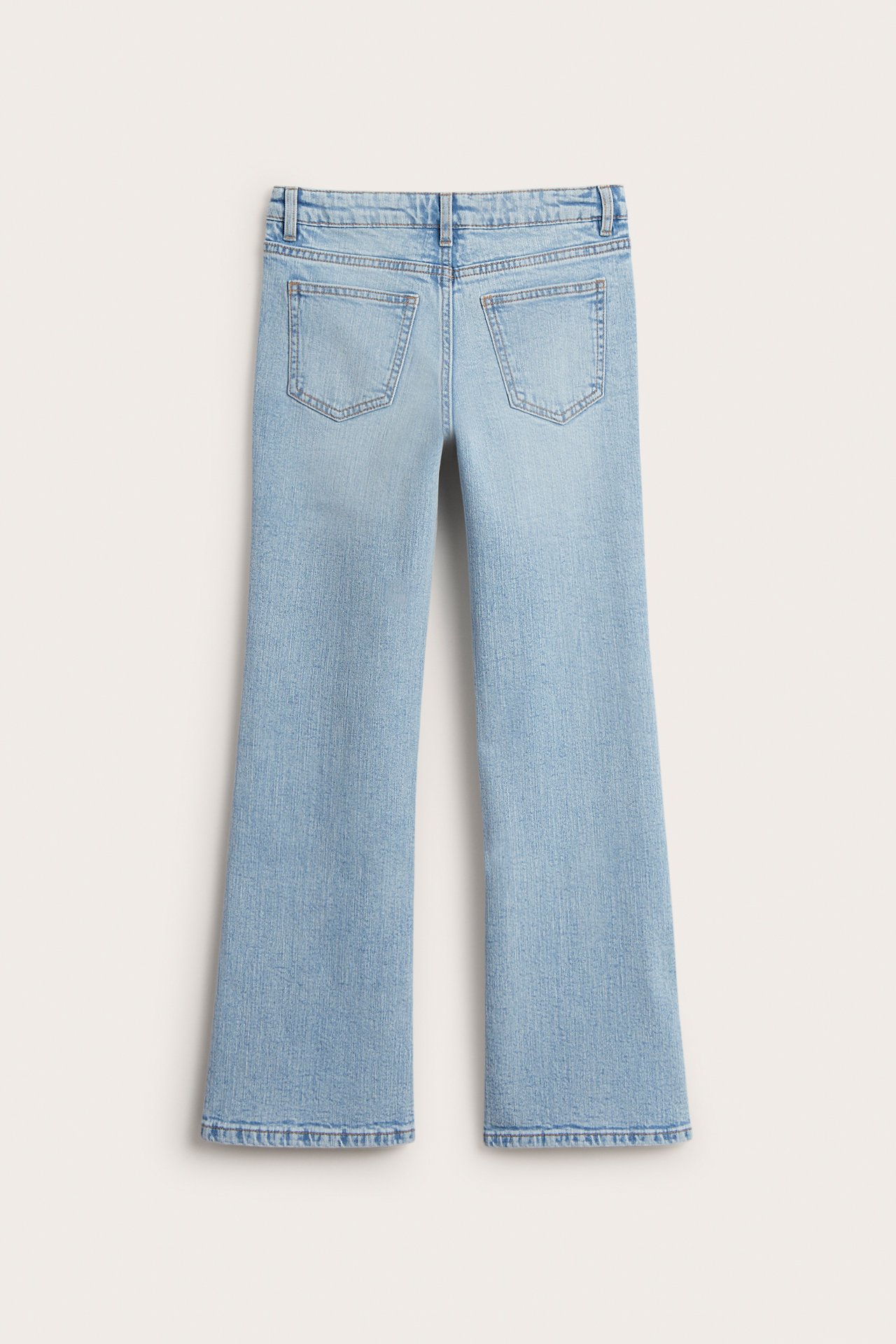 Vaaleansiniset bootcut-farkut takaa, joissa on keskikorkea vyötärö ja kaksi takataskua.