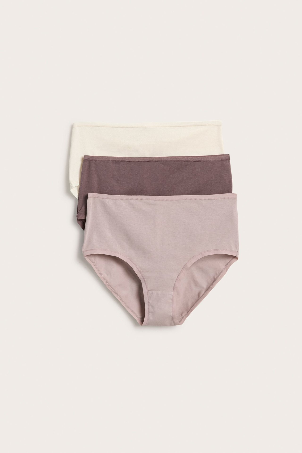 Frontvisning av tre ensfargede bomullstruser: lys plomme, mørk plomme og lys beige.