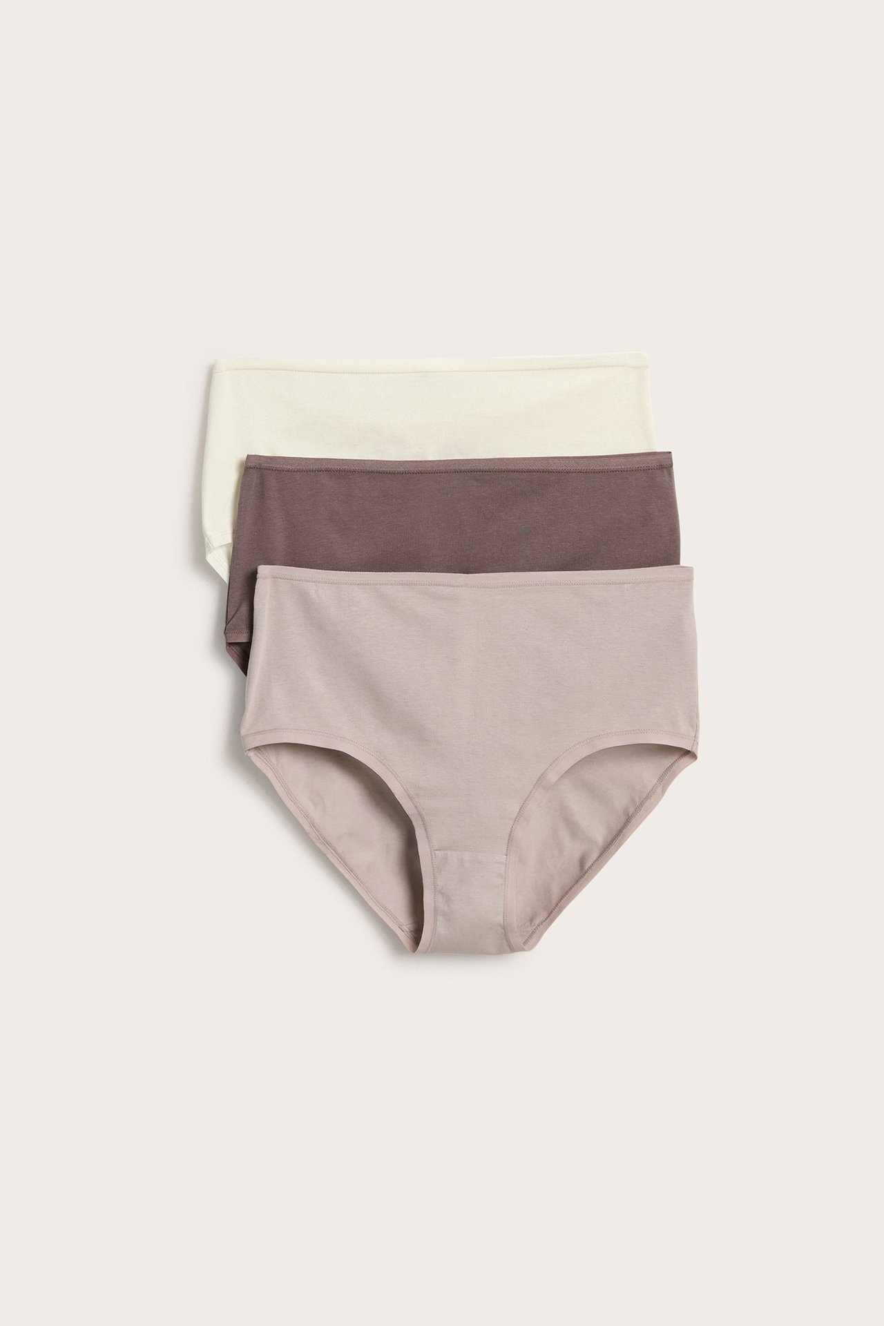 Flatt motiv av tre høye bomullstruser for dame: lys beige, brun og lys taupe.