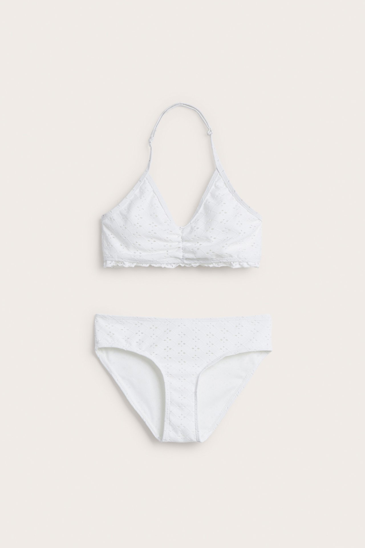 Widok z przodu, off-white dziecięcy komplet bikini z haftem angielskim, topem halterneck i figami.