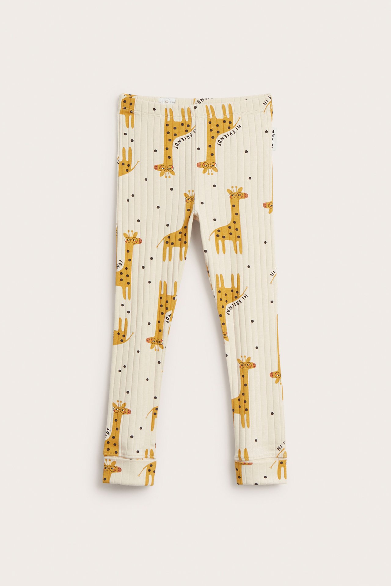 Frontvy av barnens beiga ribbade leggings med gult giraff- och svartprickigt mönster.