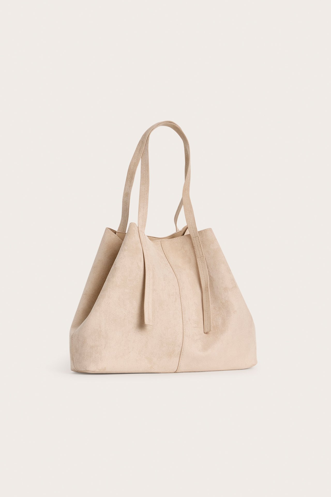 Framifrån, beige enfärgad totebag i fuskmocka med två handtag.