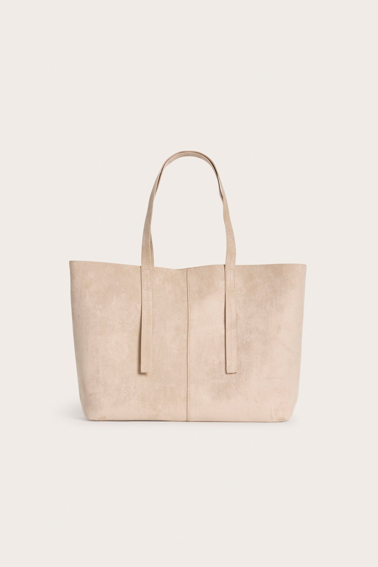Framifrån, beige enfärgad toteväska i fuskmocka med två handtag.