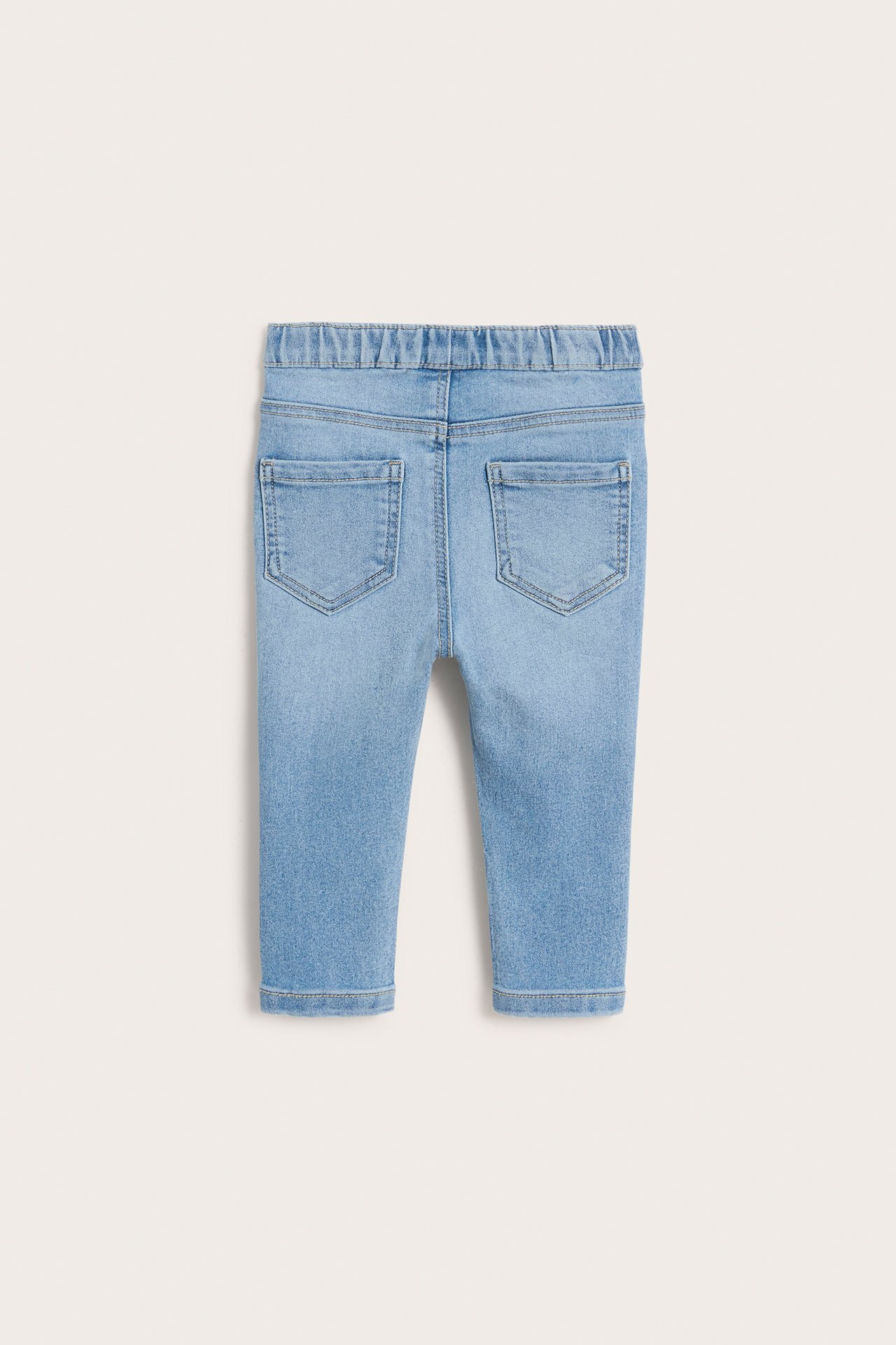 Bakifrån: Ljusblå denim jeggings för baby med resår i midjan och två bakfickor.