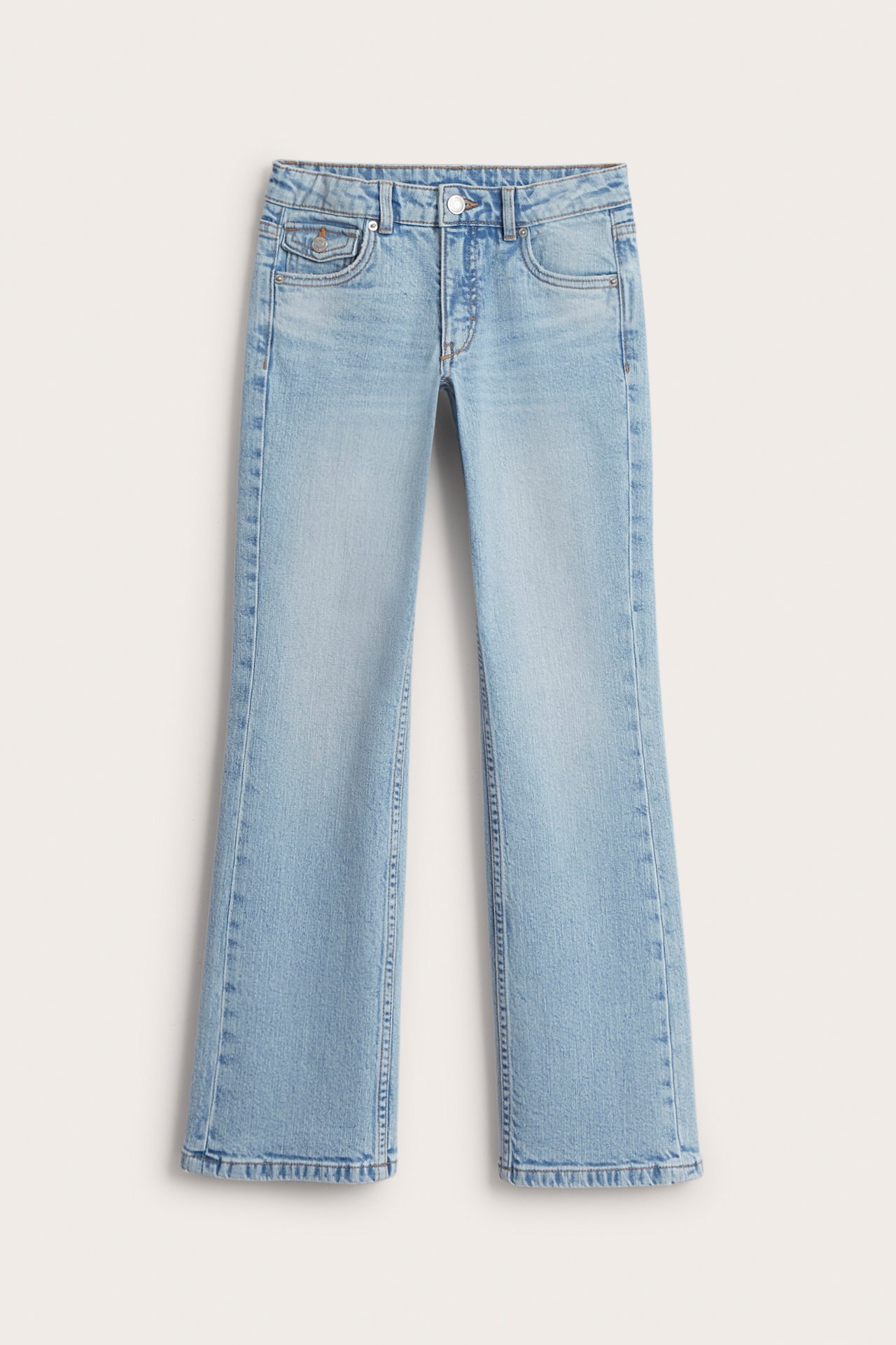 Frontvy av ljusblå bootcut jeans med låg midja i bomullsdenim för barn.