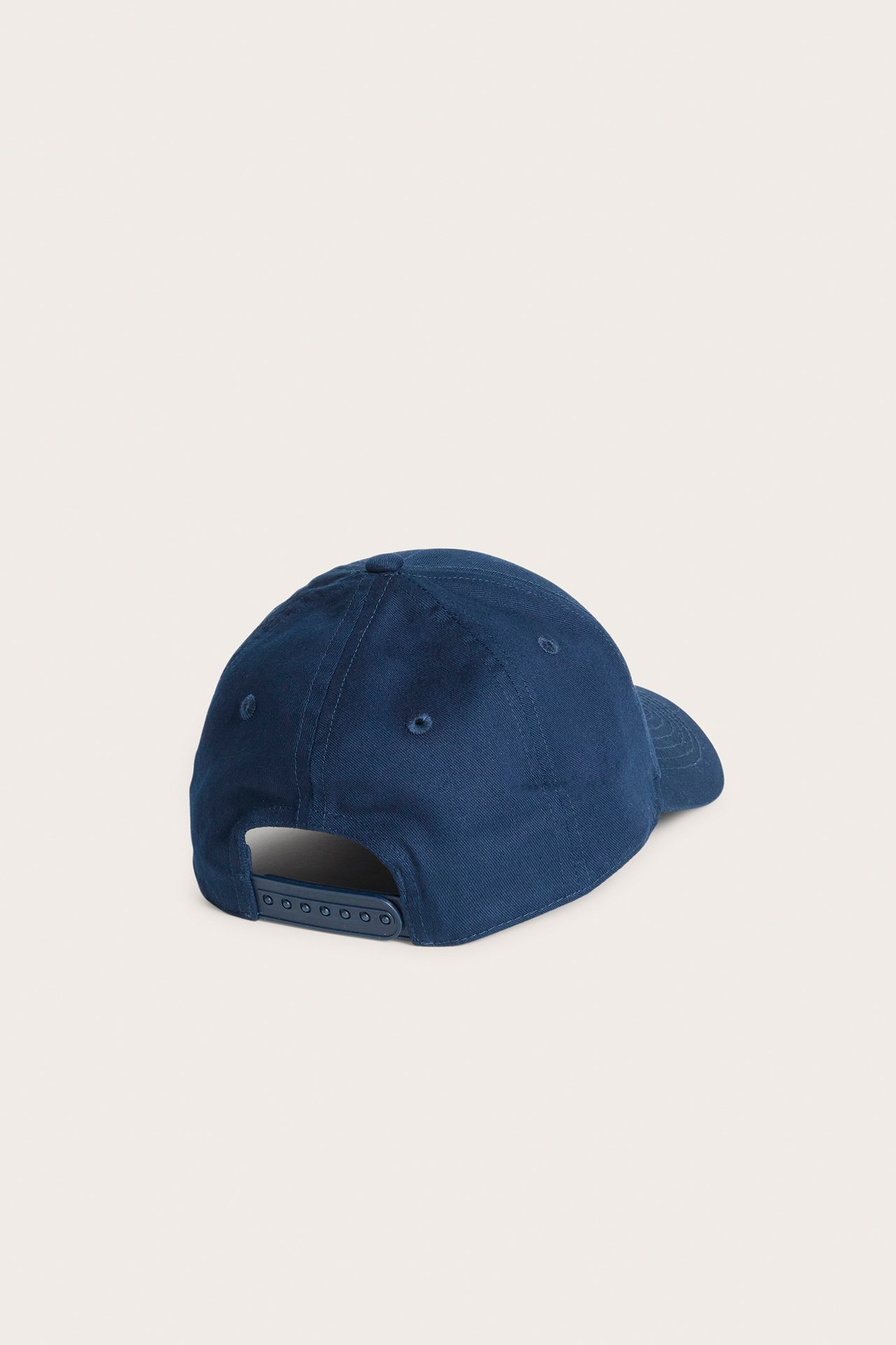 Tummansininen lippalakki takaa, säädettävällä muovisella snapback-kiinnityksellä.