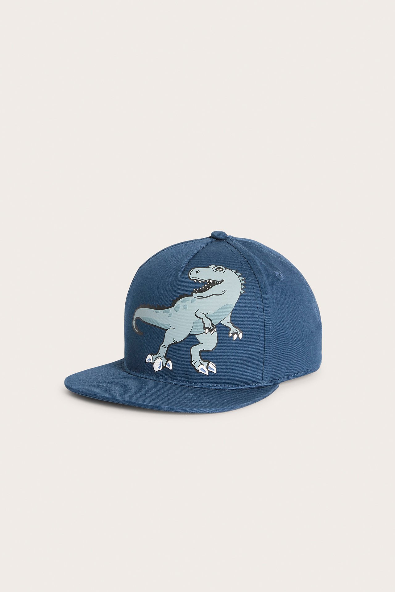 Edestä, tummansininen lasten lippalakki vaaleansinisellä dinosauruskuviolla.