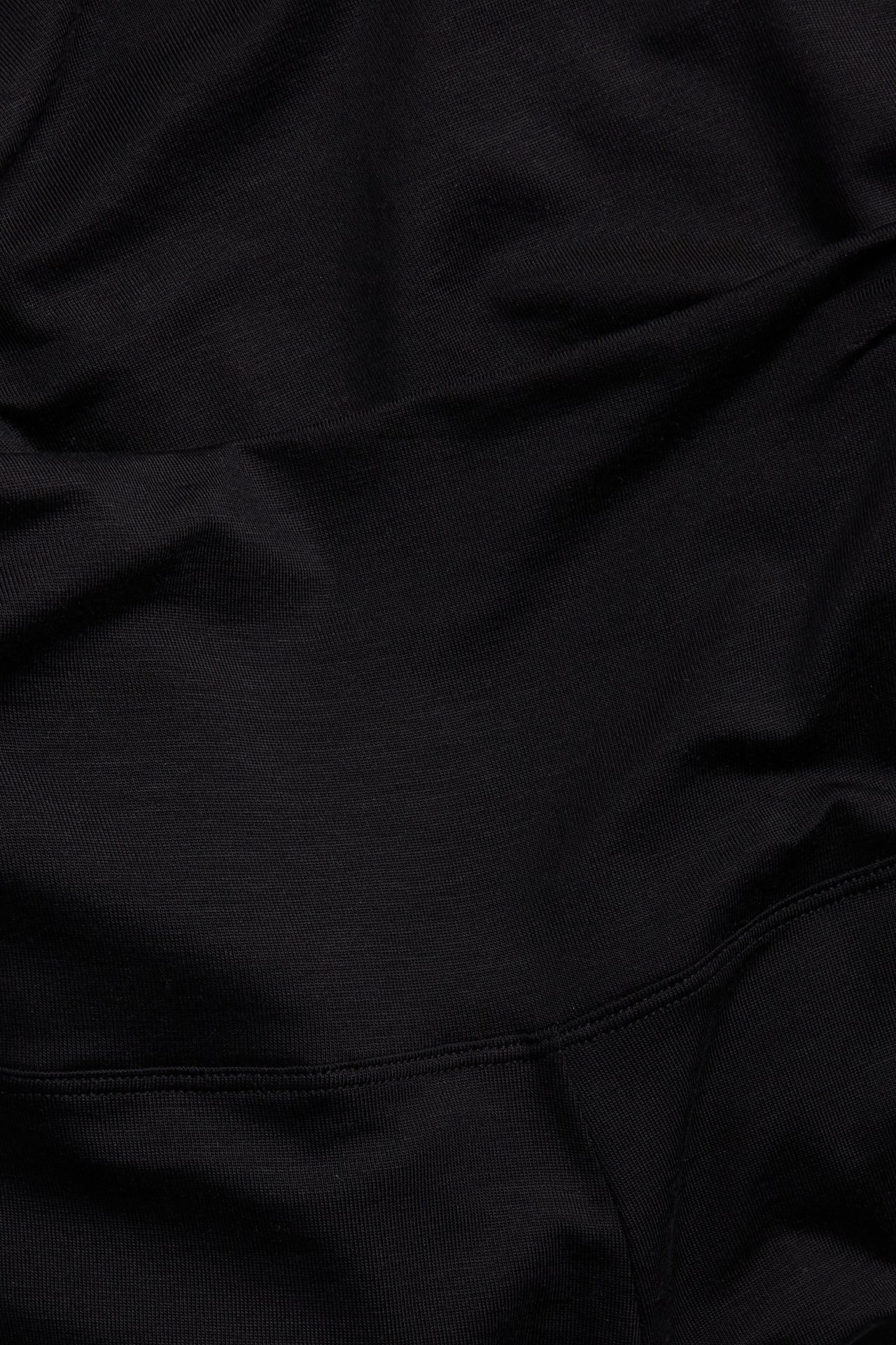 Närbild av svarta lyocellshorts med brett midjeband.