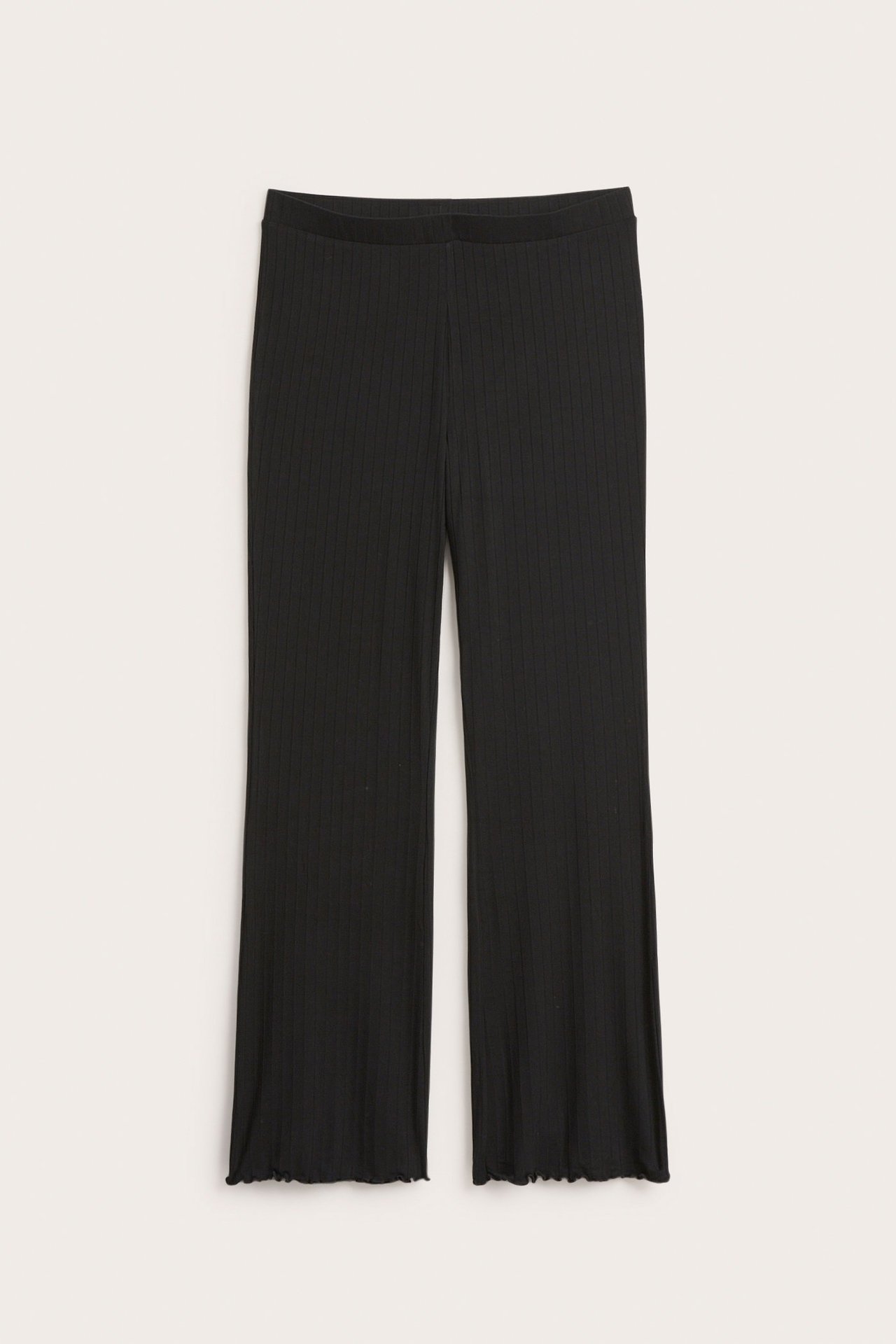 Frontvy av svarta ribbade utsvängda jerseybyxor med resårlinning och vågiga benslut.