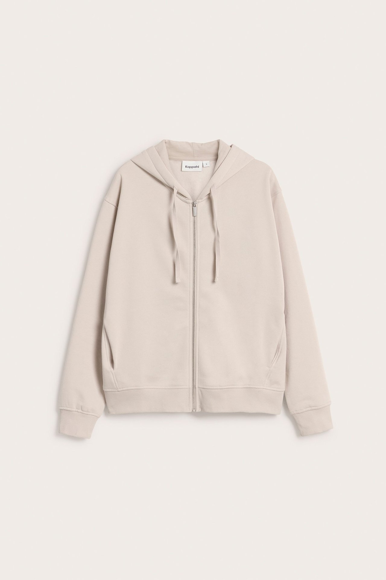 Widok z przodu: Beżowa luźna bluza z kapturem na zamek, ze sznurkami, ściągaczami i kieszeniami.