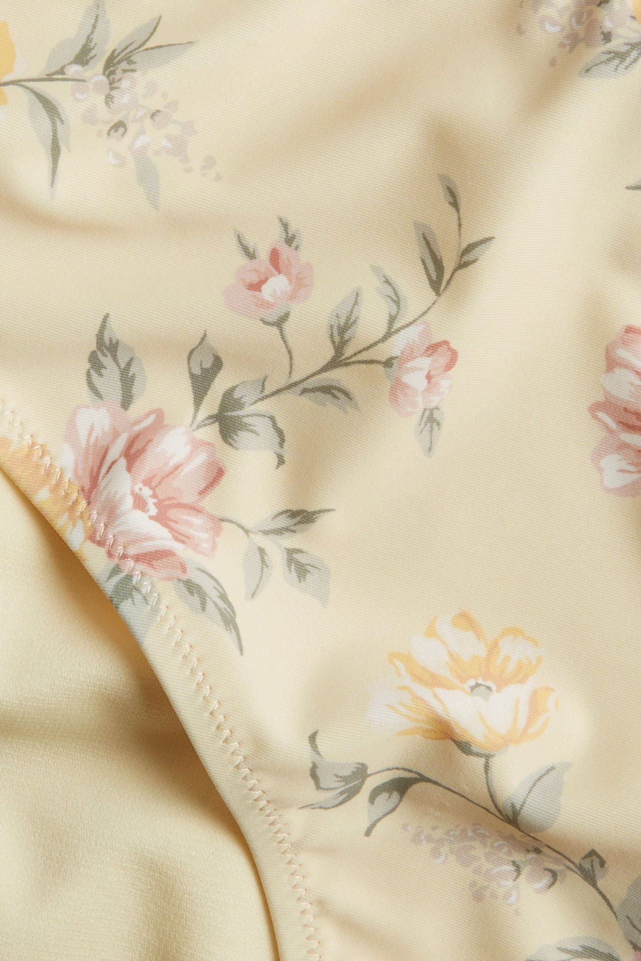 Zbliżenie na jasnożółte figi kąpielowe z wysokim stanem w różowo-żółty kwiatowy wzór.