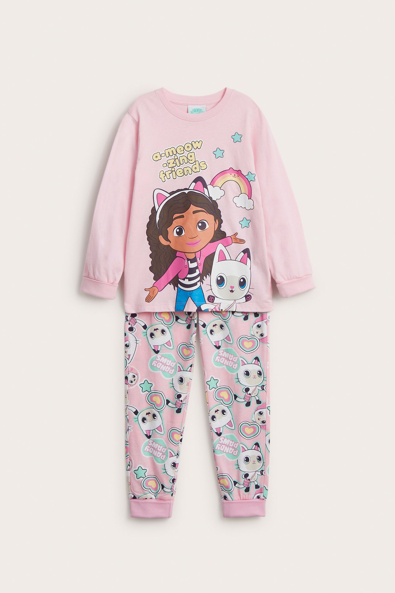 Framsida av ett rosa pyjamasset i bomull för barn med Gabbys Dollhouse-tryck på tröjan och mönstrade byxor.