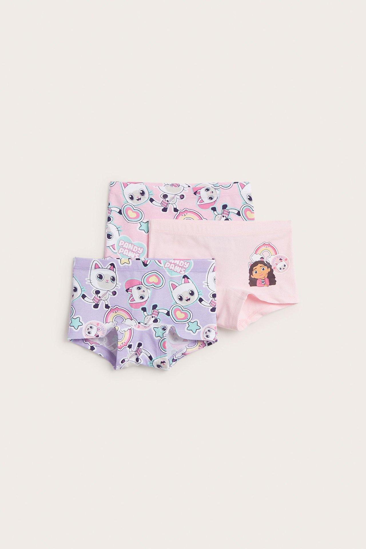 Widok z przodu trzech dziecięcych wzorzystych bokserek z mieszanki bawełny: jedne różowe, jedne jasnoróżowe i jedne jasnofioletowe.