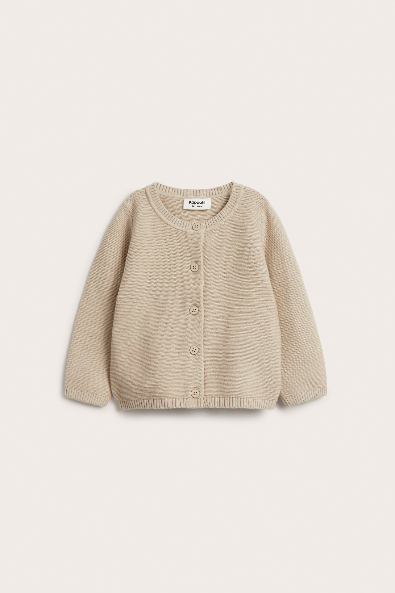Frontvy av en enfärgad beige stickad bomullskofta för baby med rund hals och knäppning fram.