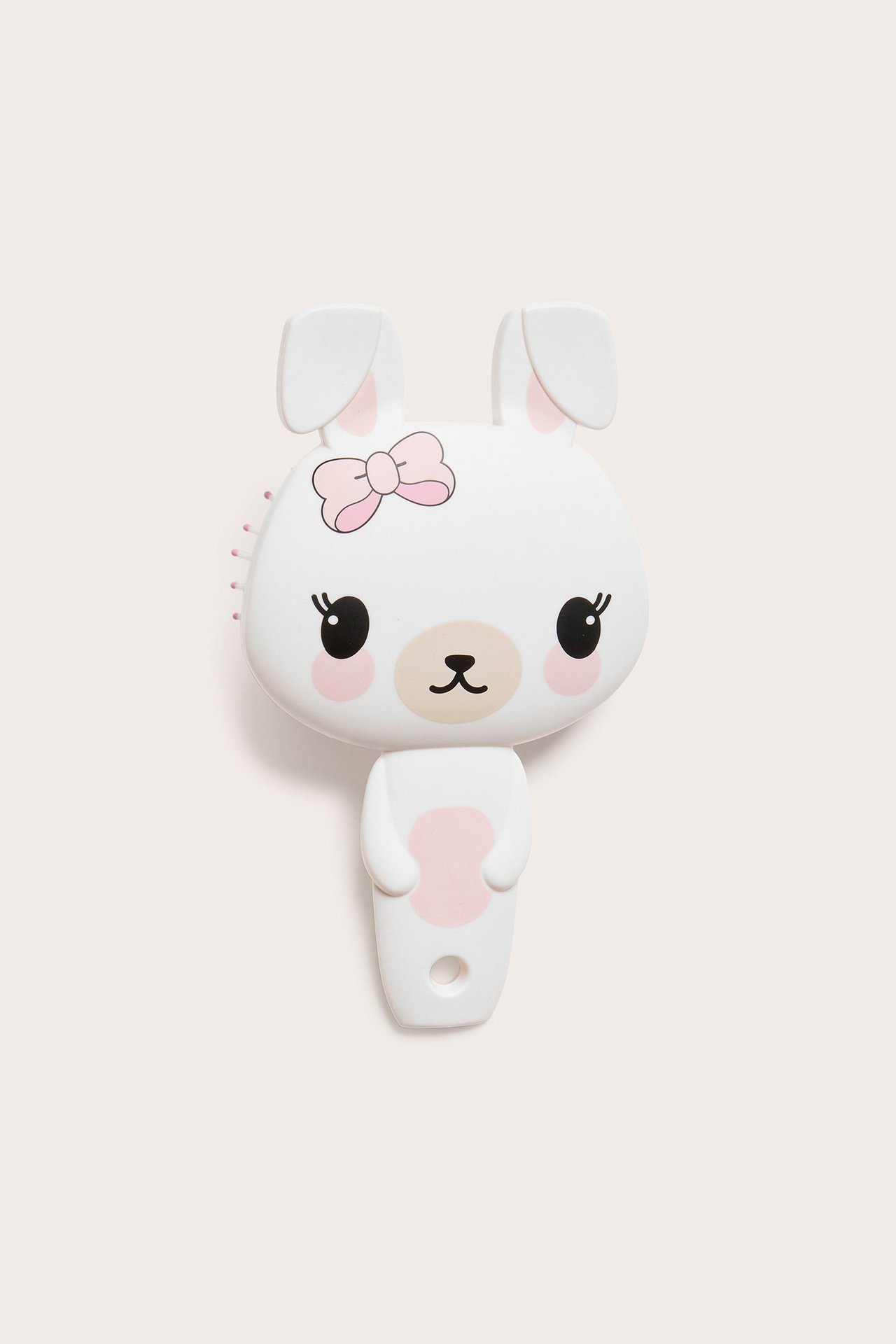 Widok z przodu: Ecru plastikowa szczotka do włosów w kształcie królika z różową kokardą i nadrukowaną twarzą.